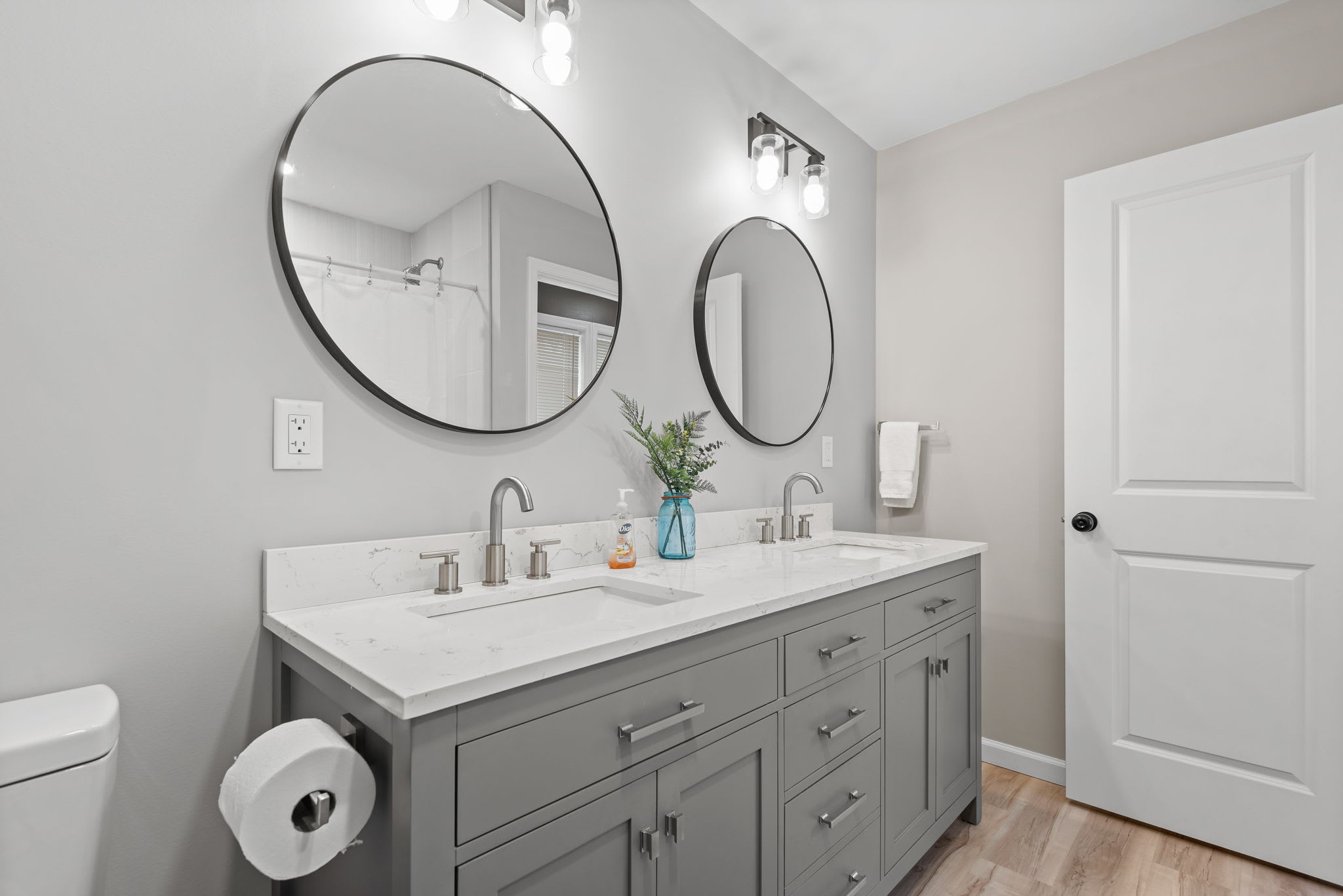 Soft neutral tones, ample counter space, and thoughtful decor create a relaxing and sophisticated space for guests to freshen up in comfort.