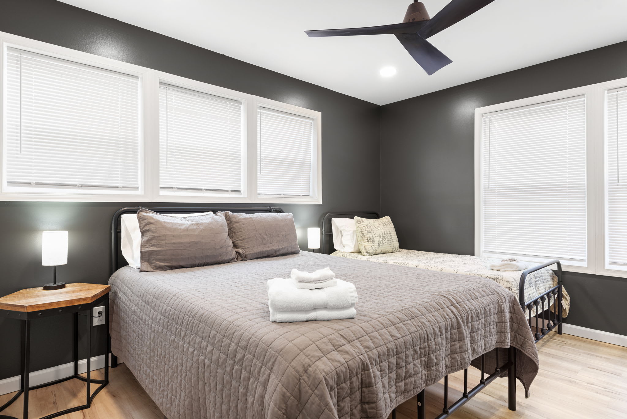 A Modern & Minimalist Escape
Featuring a plush bed, sleek black accent wall, and contemporary furnishings, this room is designed for both comfort and style.