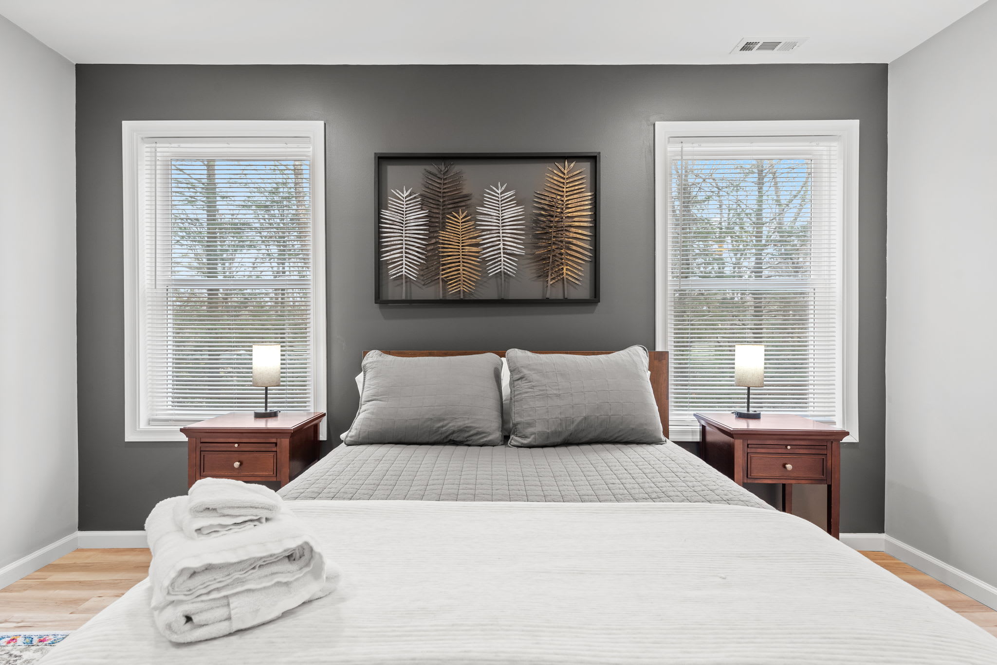 Large windows let in natural light, highlighting the elegant design and cozy atmosphere of this modern bedroom ideal for unwinding in style.