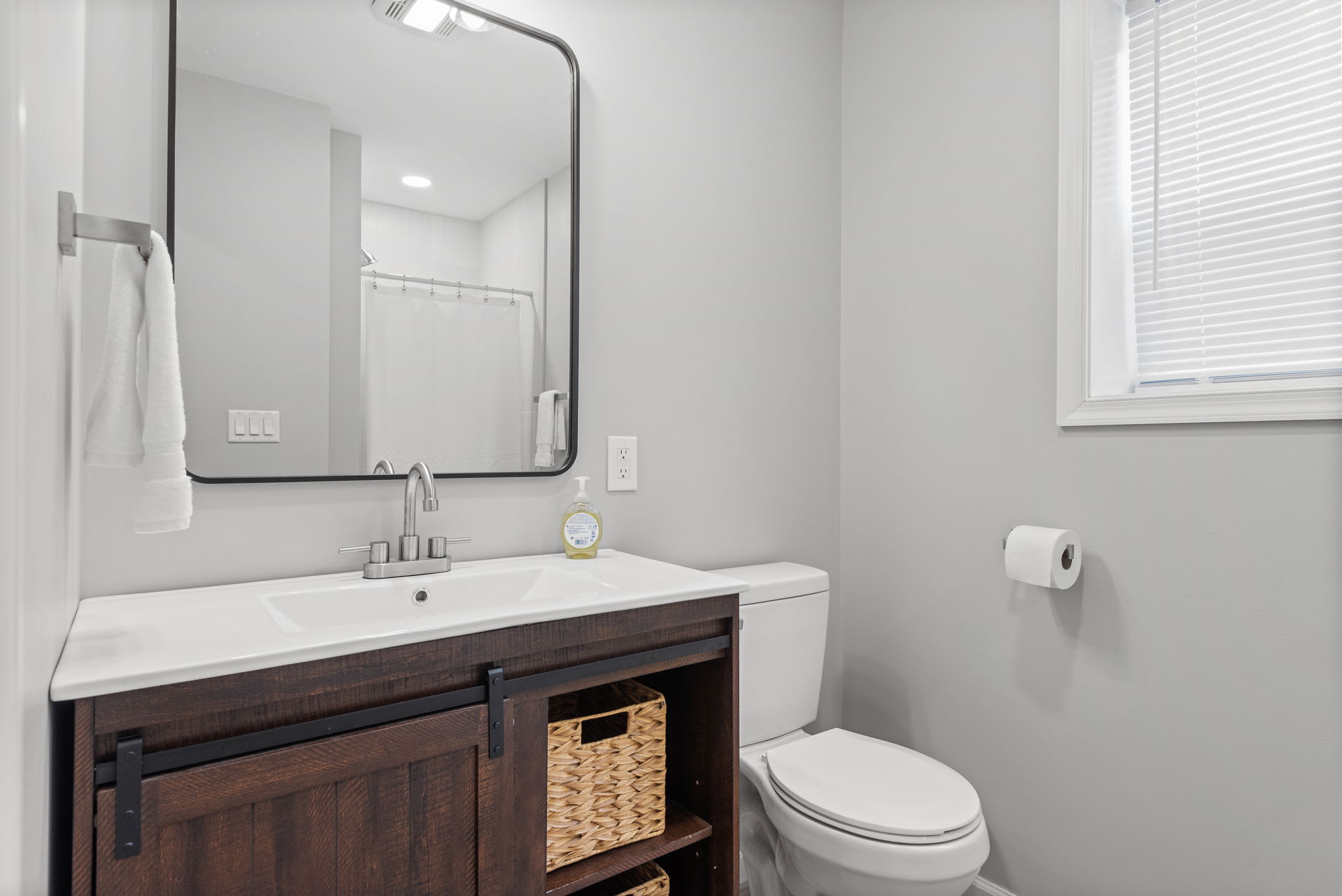 Sleek & Simple Bathroom Design
A stylish bathroom with a dark wood vanity, elegant mirror, and minimalist decor offering both function and charm for a refreshing stay.