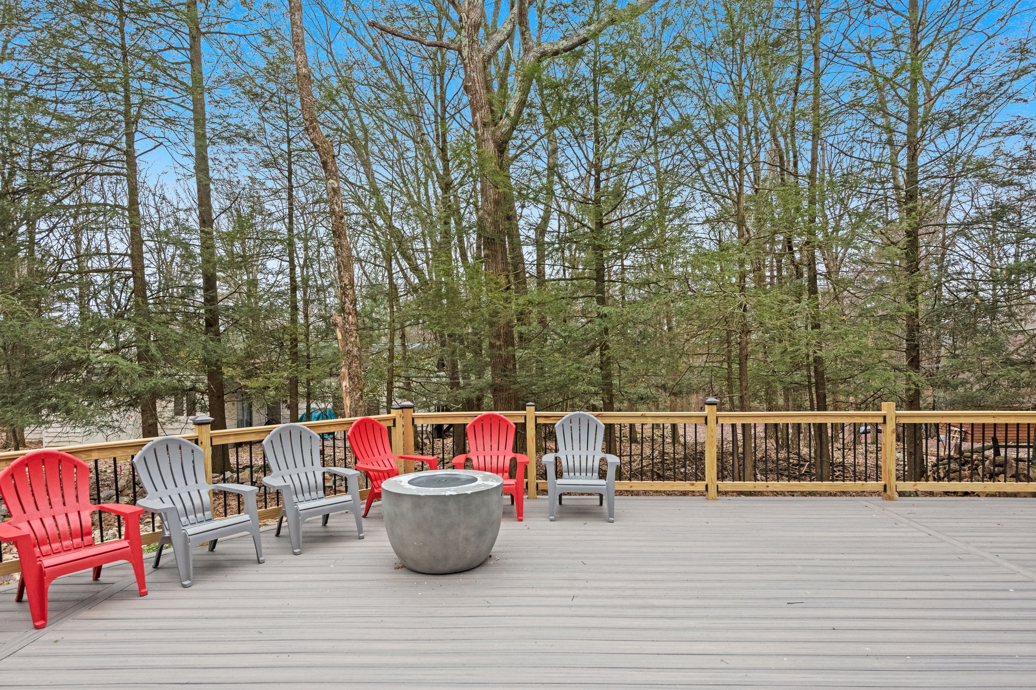 Spacious Deck with Cozy Fire Pit
Surrounded by lush trees, this expansive deck offers a variety of Adirondack chairs and a cozy fire pit perfect for gathering with friends and family.