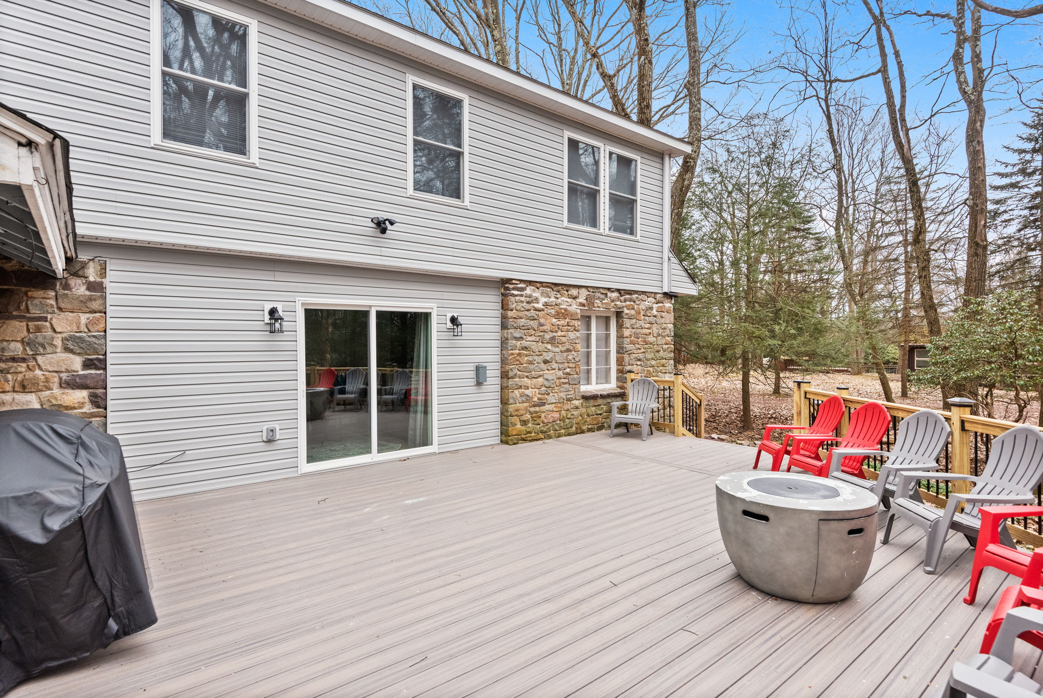 The spacious deck offers plenty of seating, a built-in fire pit, and seamless indoor-outdoor flow—an ideal gathering space for relaxing under the stars.