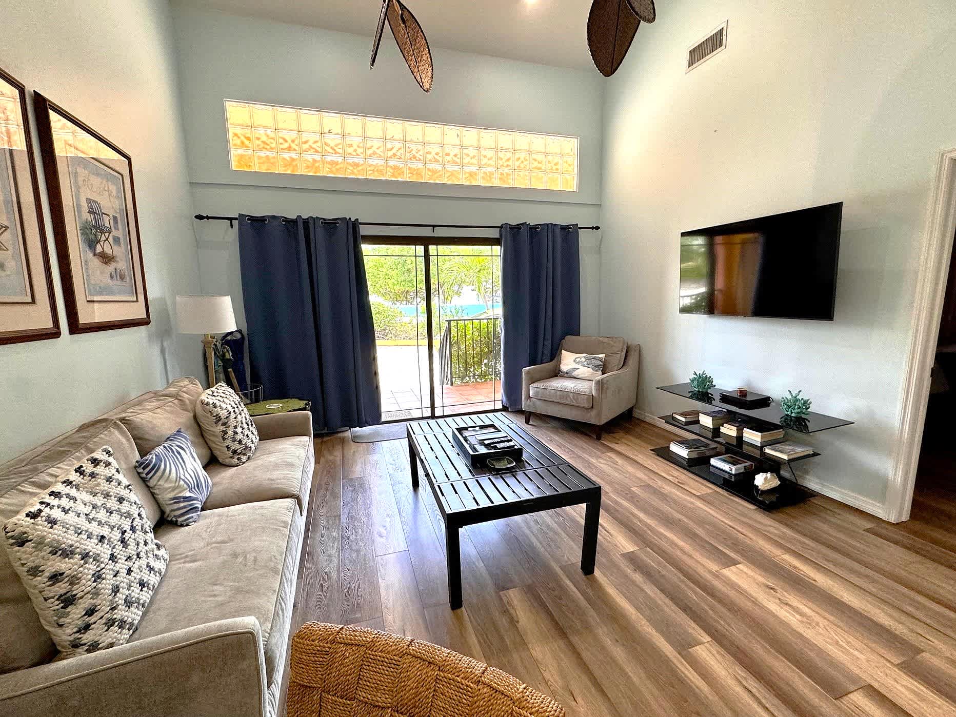 Living room view to patio that has views of the beach and sea across the street