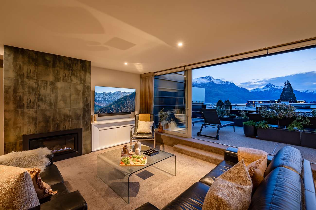 Spacious Living Room with Modern Elegance and Scenic Views
This sophisticated living area blends modern design with cozy luxury, featuring plush seating and a fireplace, perfect for unwinding after exploring Queenstown's ski fields or wine tours.