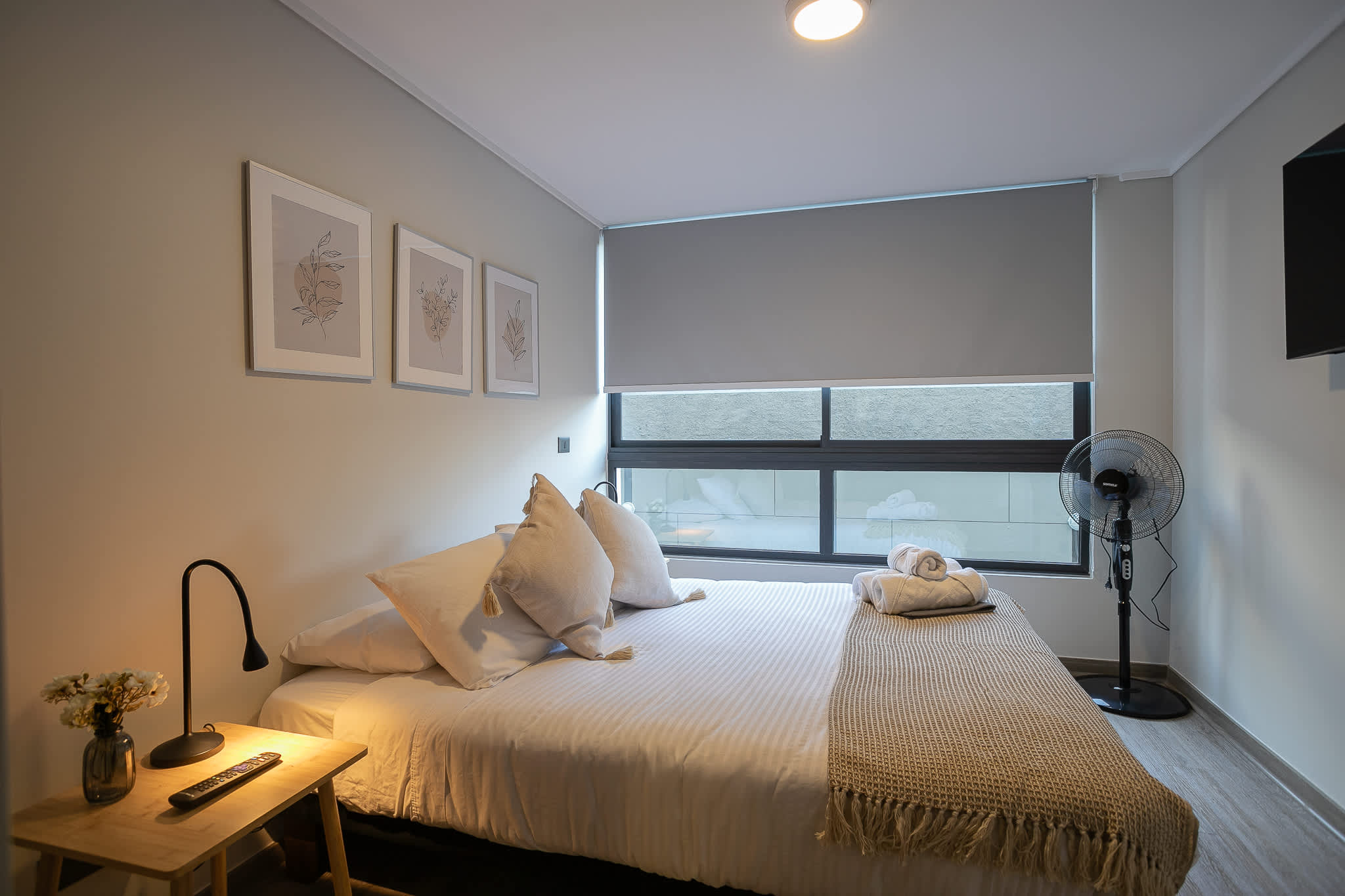 Relax in this cozy, well-lit bedroom with modern decor and a comfortable bed, perfect for a restful stay.