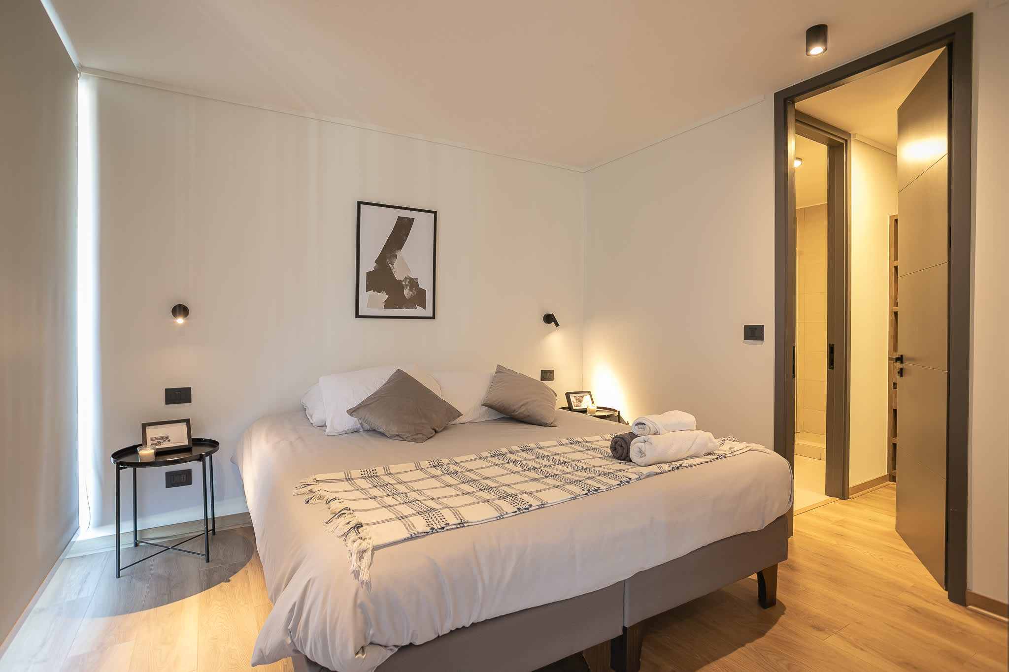 Relax in this cozy bedroom with modern decor and convenient access to a private bathroom, perfect for a restful stay.