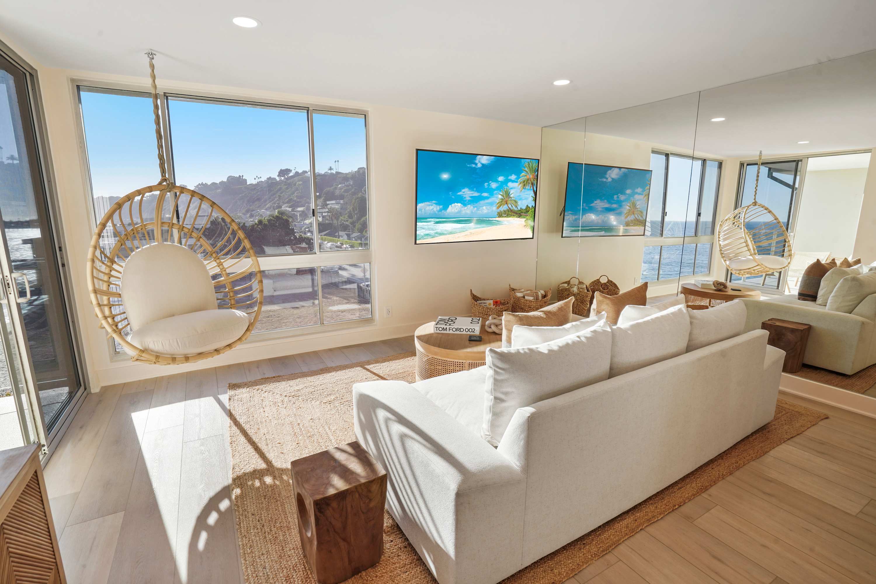 Sunlit living room offering panoramic ocean views and elegant, modern decor.