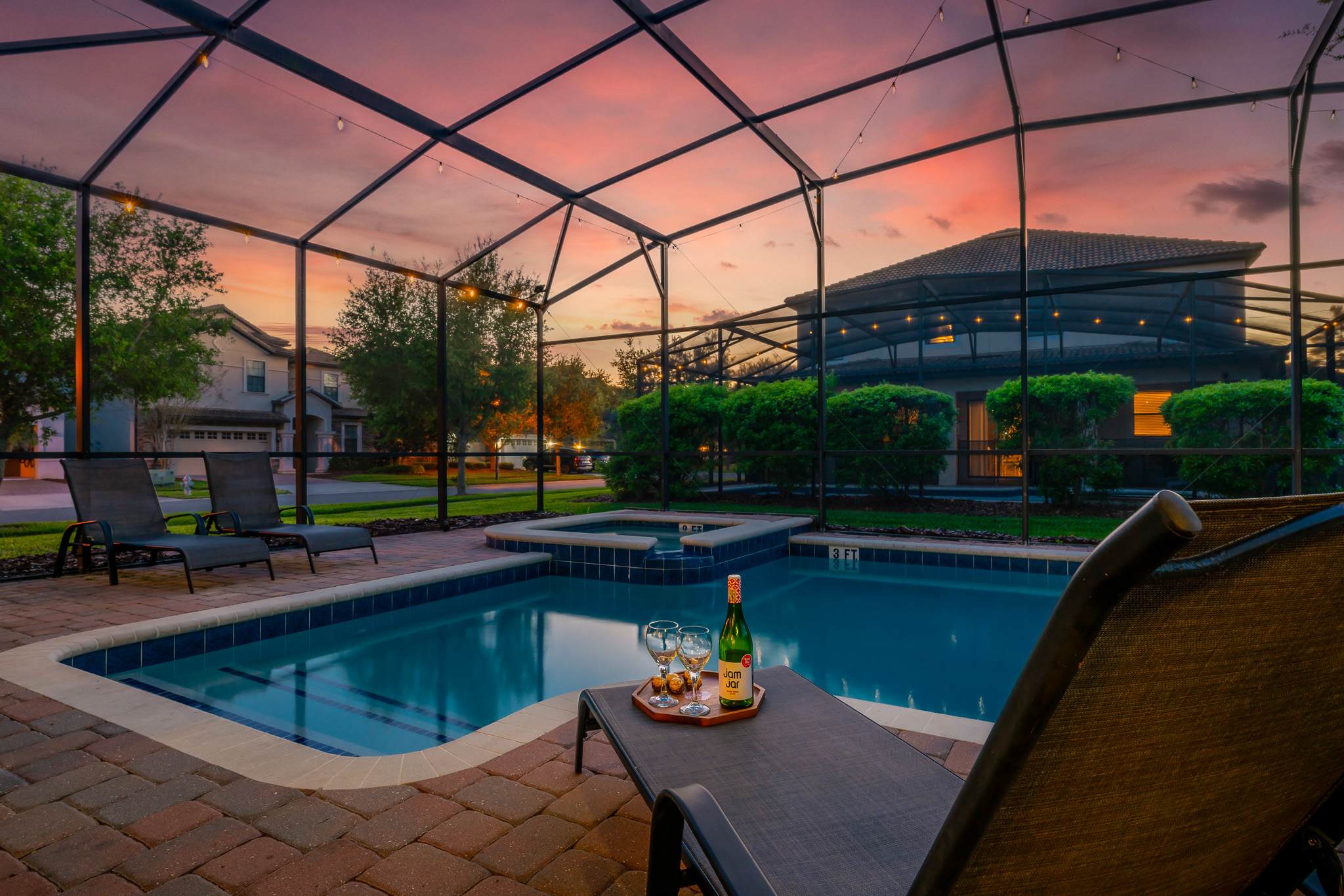 Screened-in pool glowing at dusk, perfect for evening swims.
