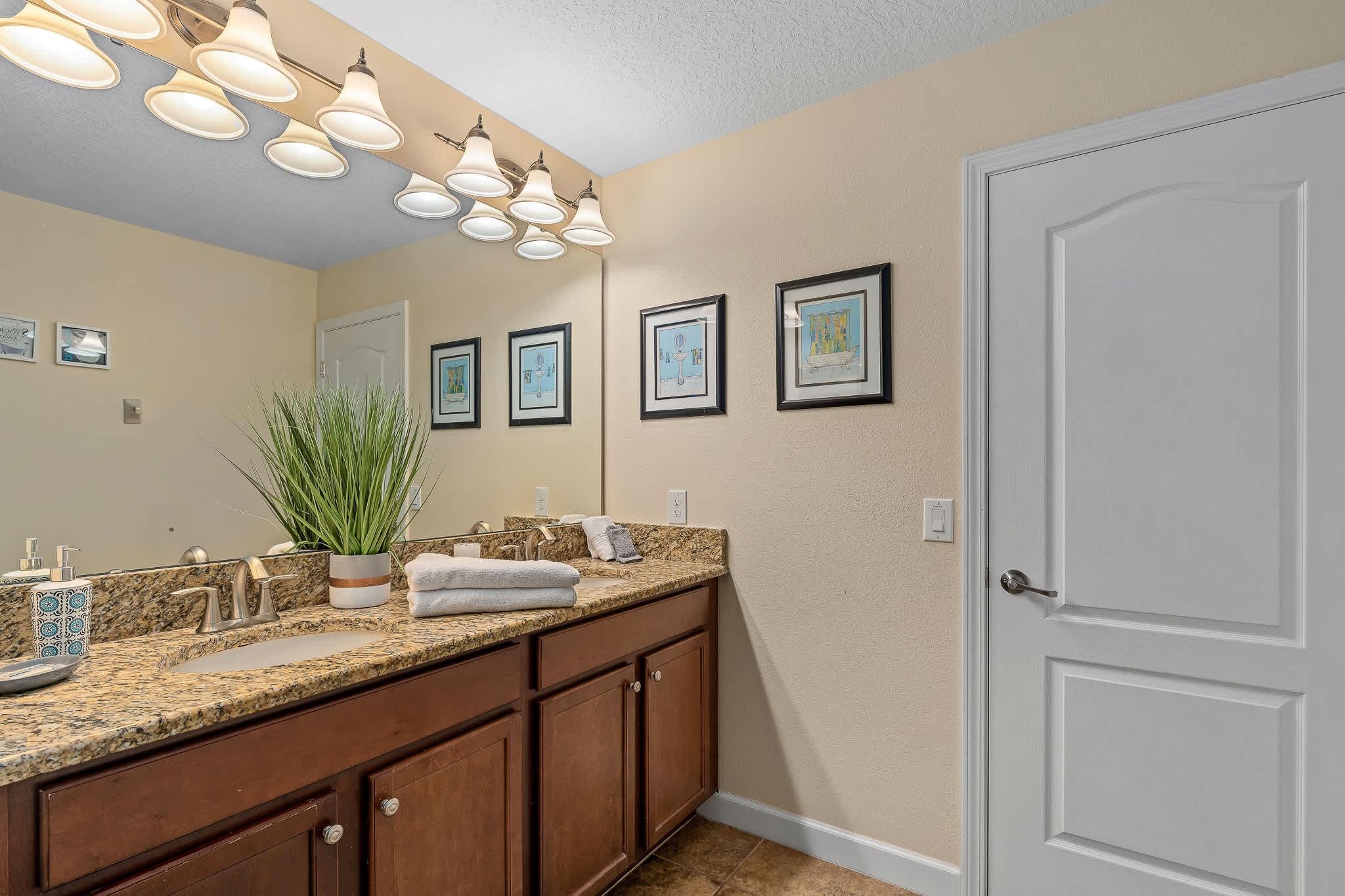 Bathroom vanity w/ sink, mirror, and bright lighting for smooth morning routines.