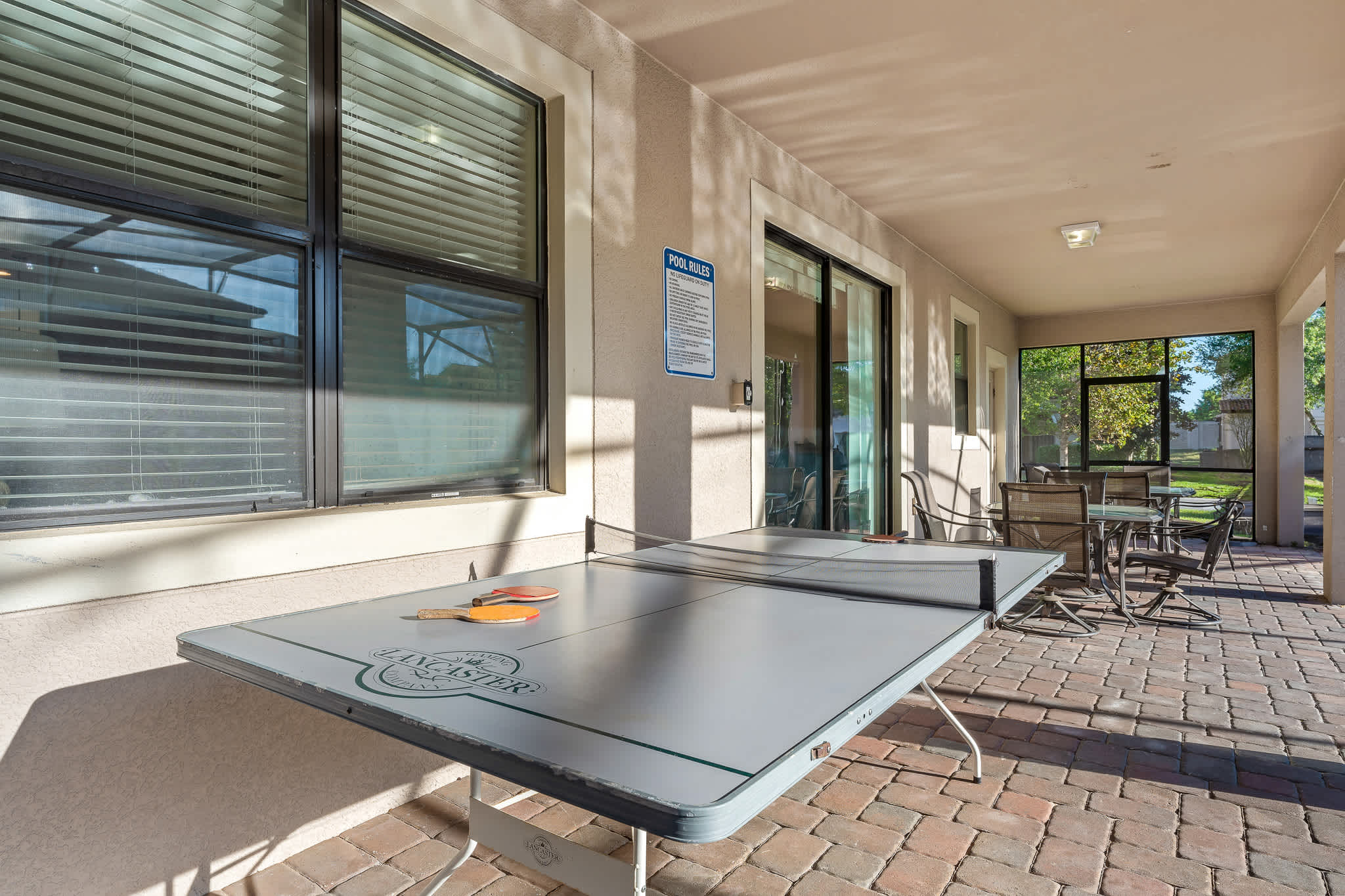 Covered patio seating overlooking the pool, great for lounging outdoors.