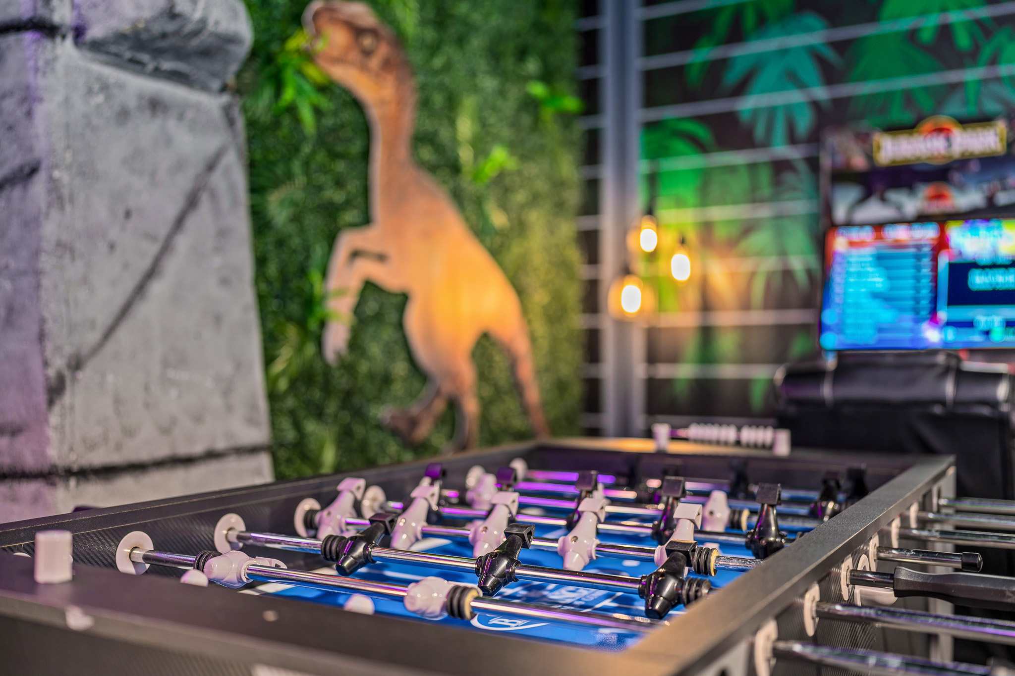 Arcade-style game area w/ vibrant lights for playful competition.