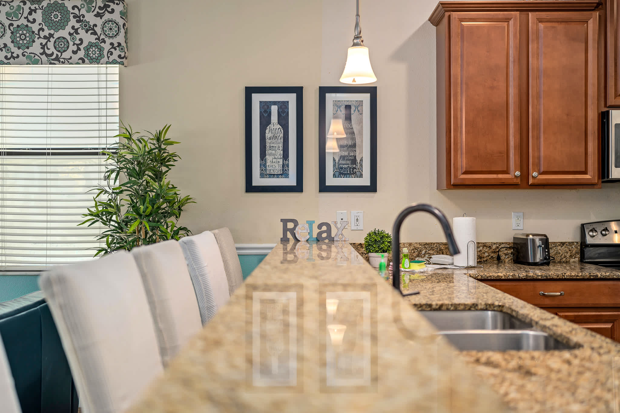 Dining area w/ seating and wall art, warm and inviting for gatherings.