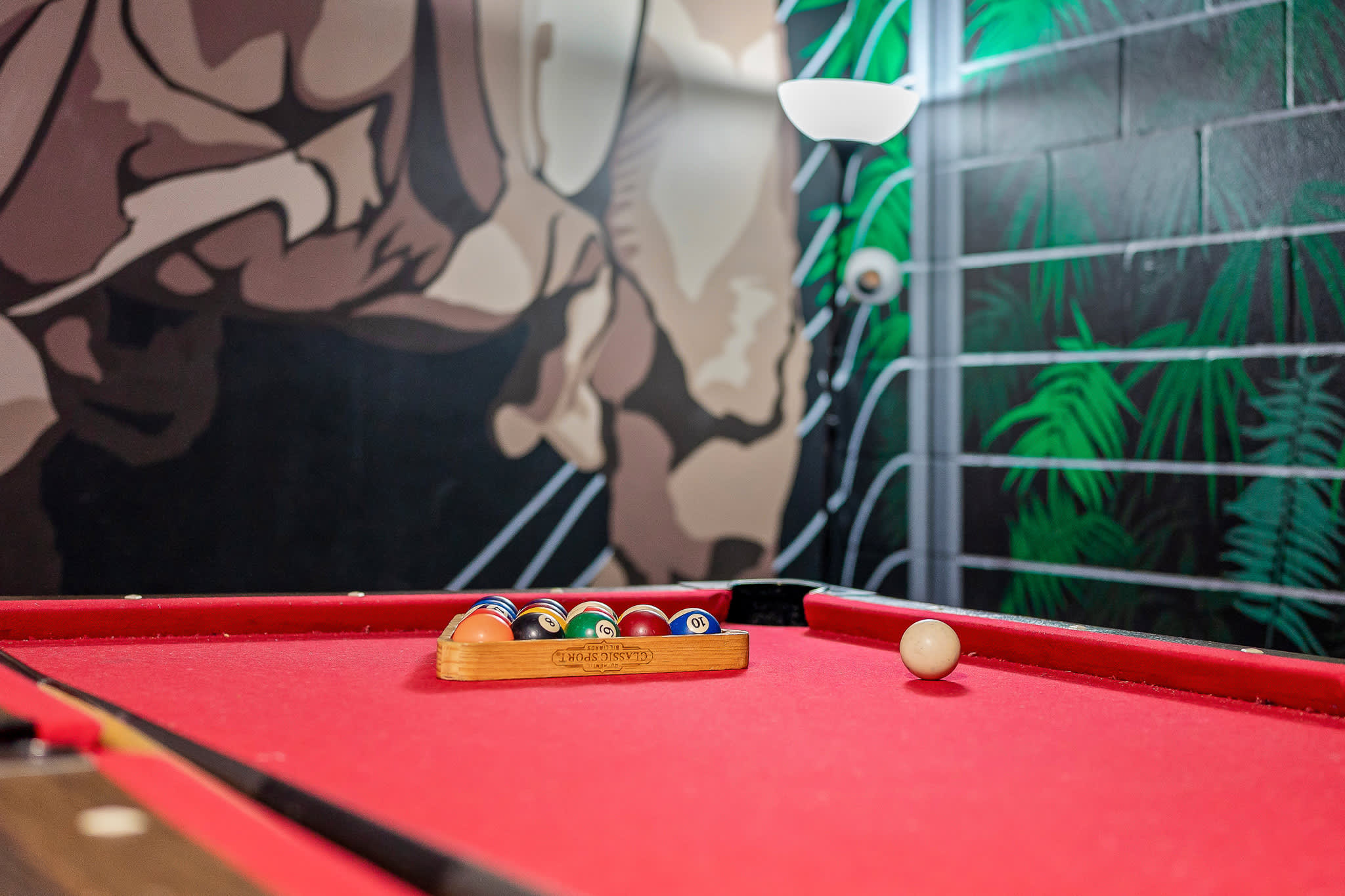 Game room w/ pool table and bold lighting for late-night fun.