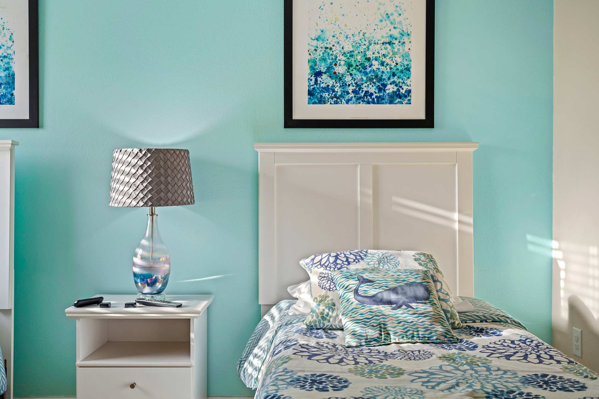 Bedroom corner w/ bed and wall art creating a relaxed vibe.