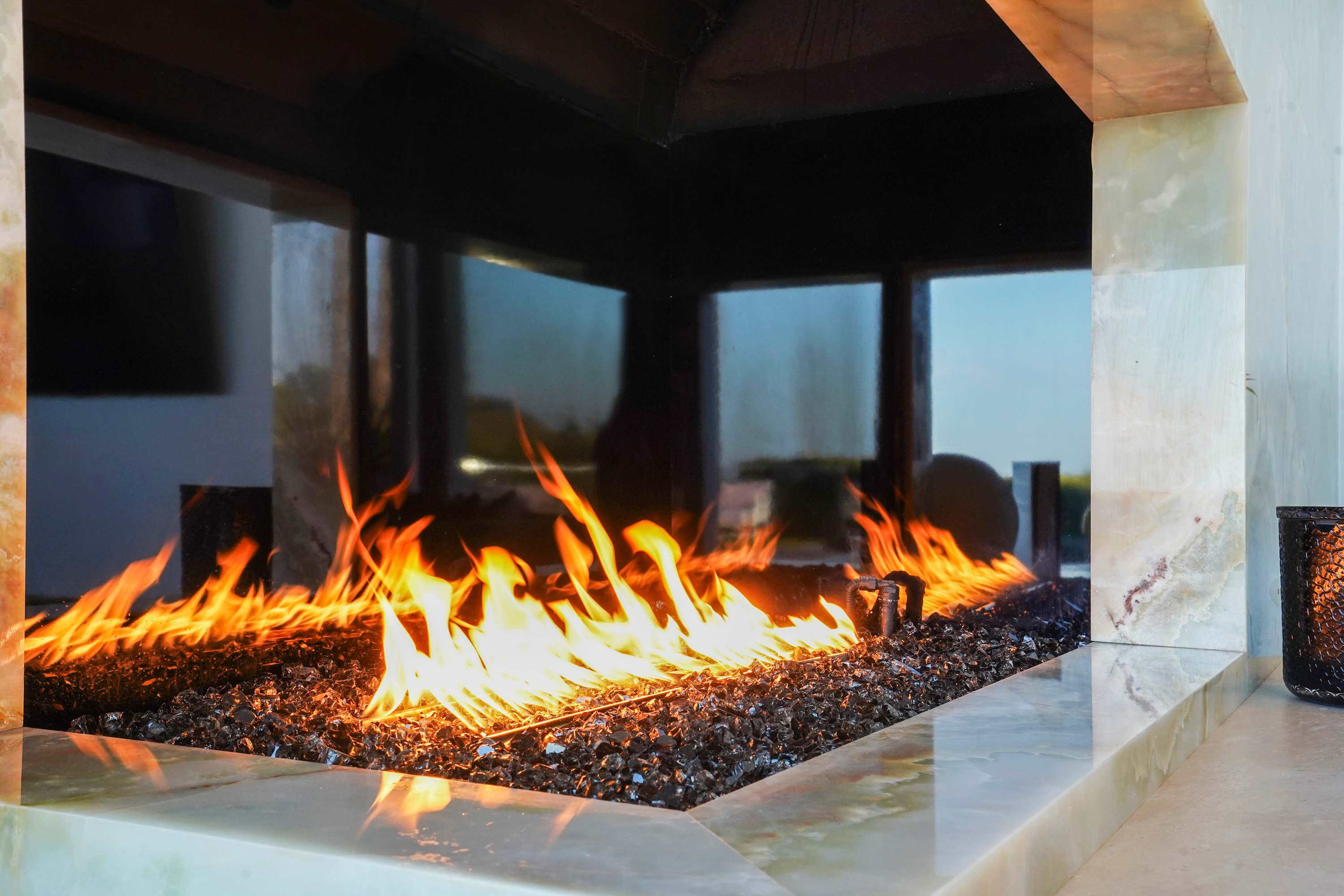 A striking green onyx fireplace with brass detailing, the centerpiece of the living area.