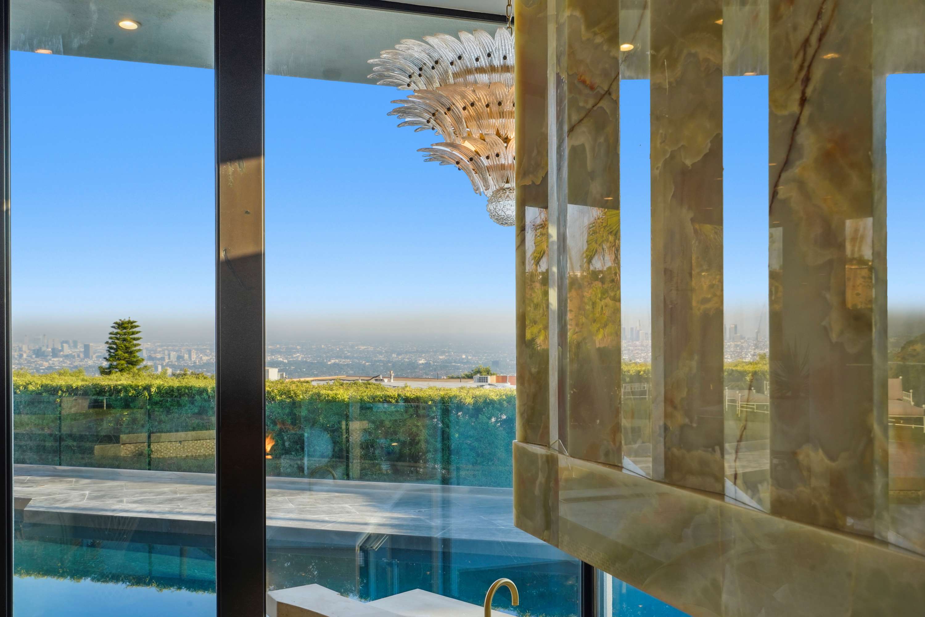 Glass doors open to a private pool, blending indoor elegance with outdoor serenity.