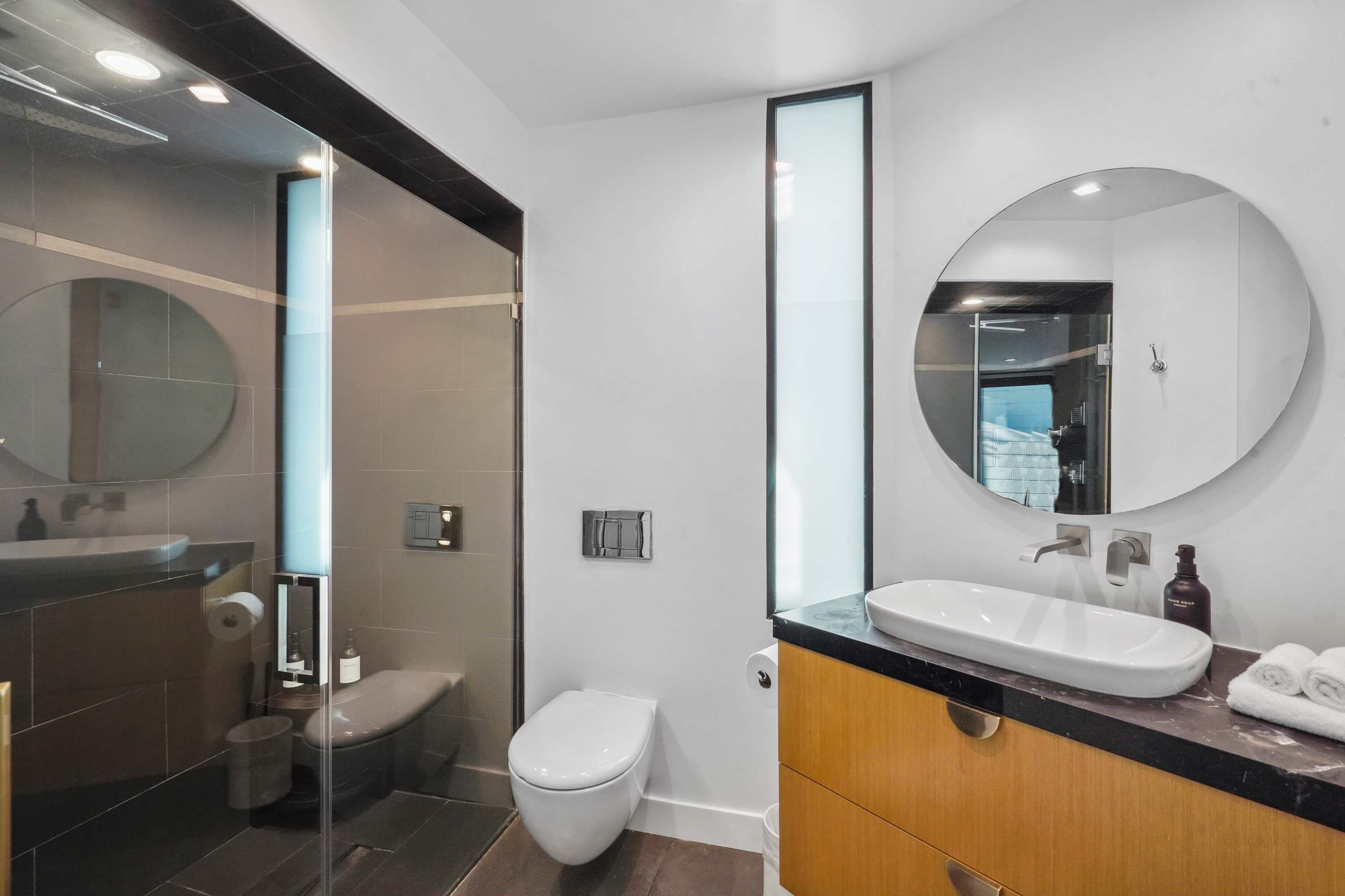Modern en-suite bathroom with marble finishes and a walk-in shower.