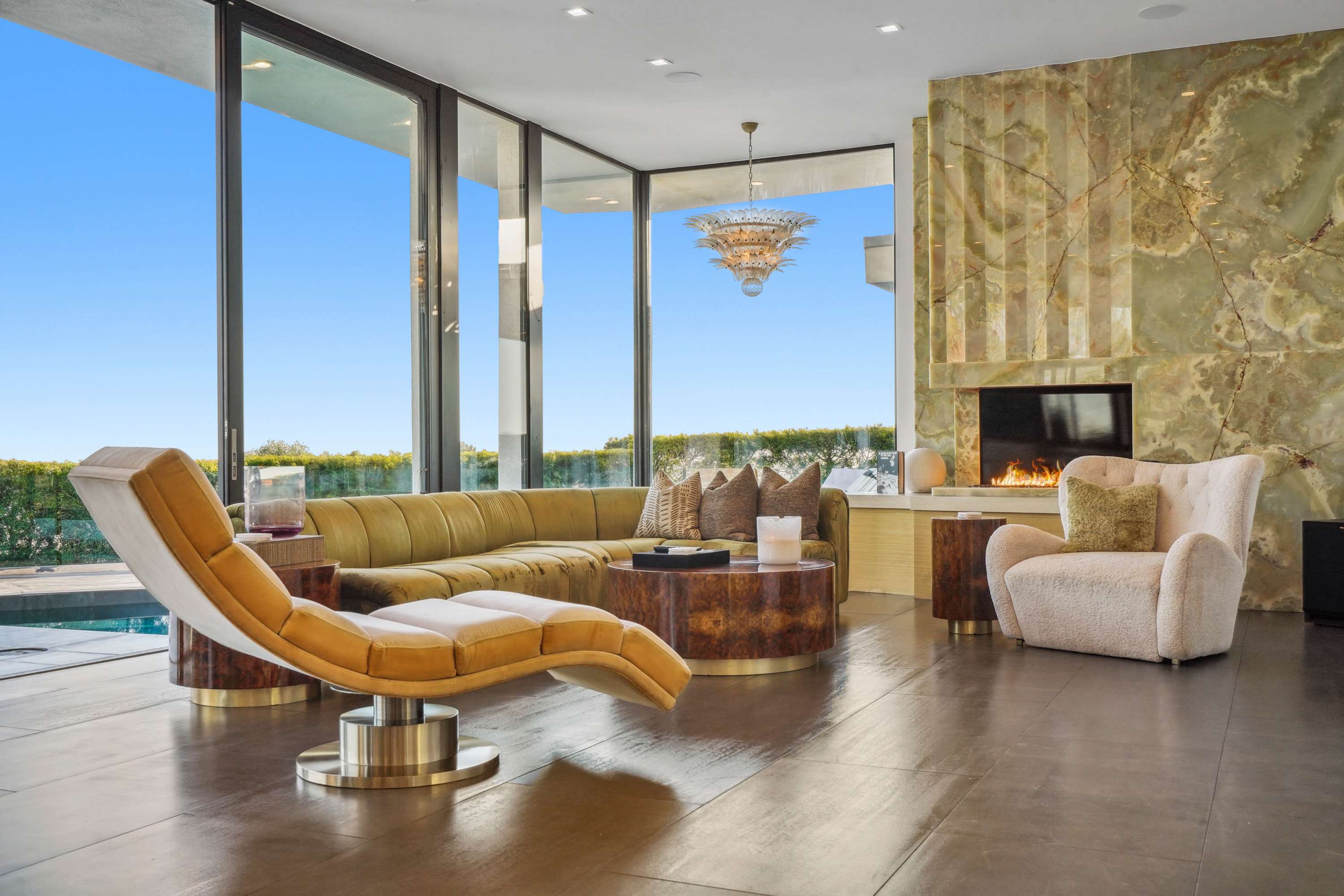 Plush seating, onyx fireplace, and expansive floor-to-ceiling windows with stunning views.