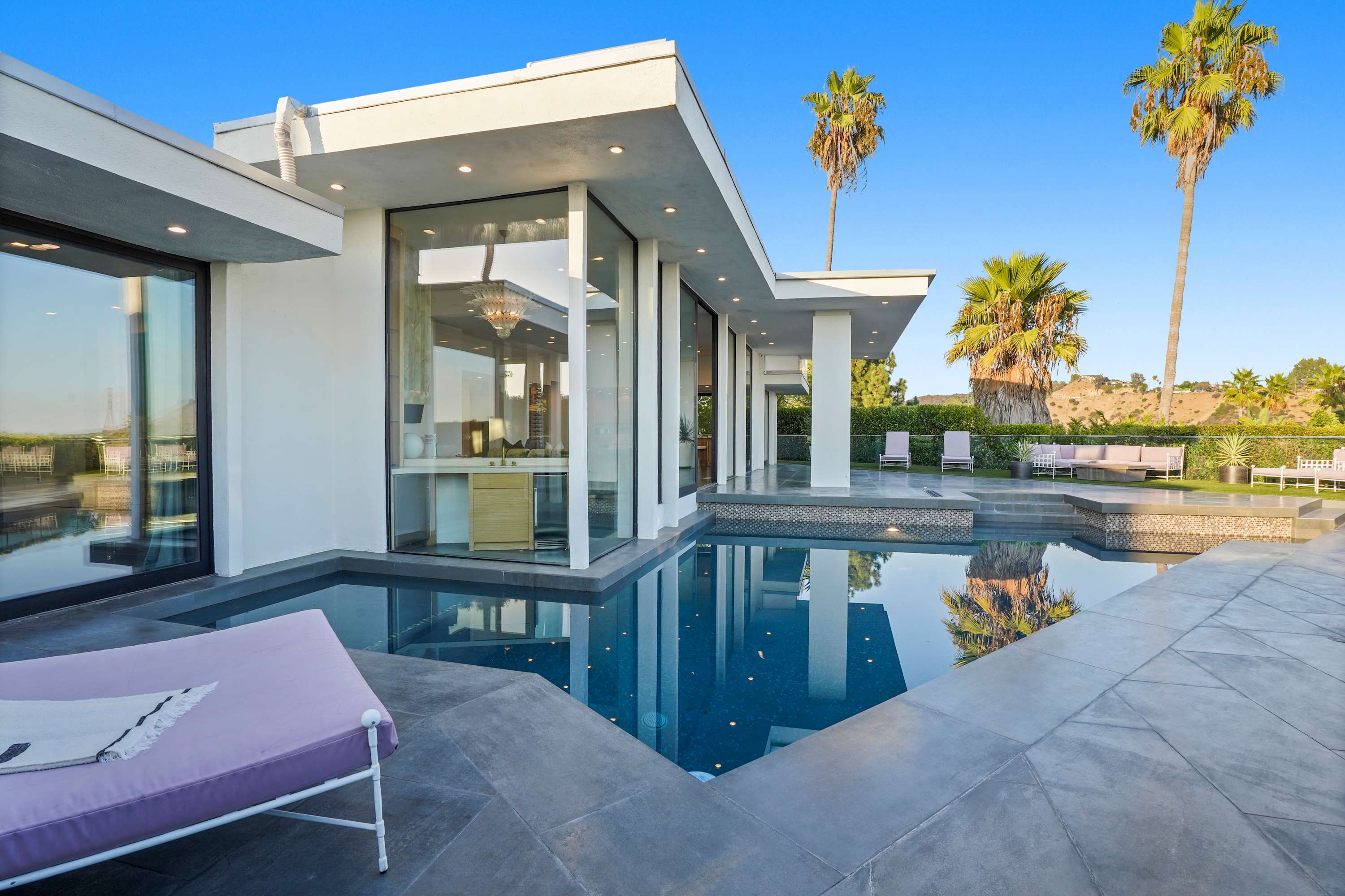 Sleek pool framed by modern architecture and city skyline views.