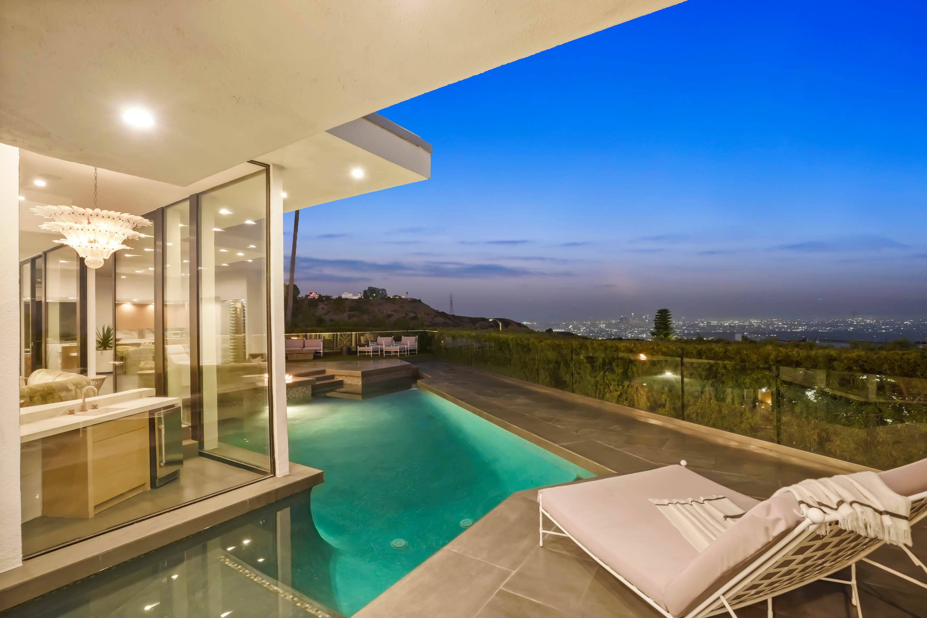 Tranquil pool area surrounded by chic lounge furniture and sweeping city views.