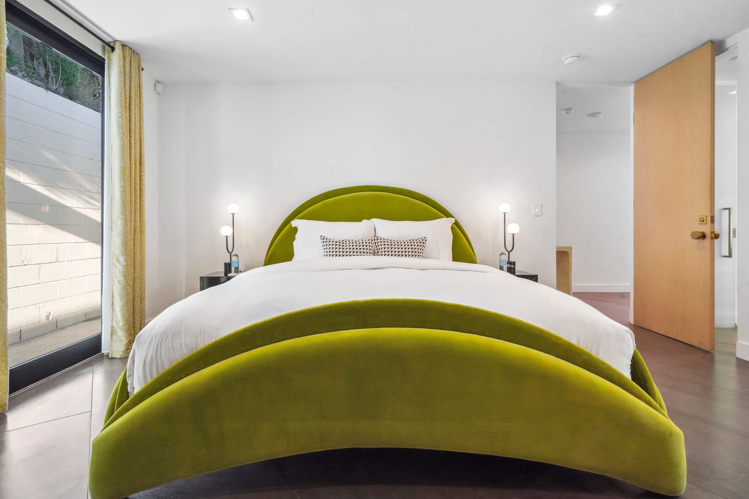Guest bedroom featuring custom woodwork, bold decor, and outdoor access.