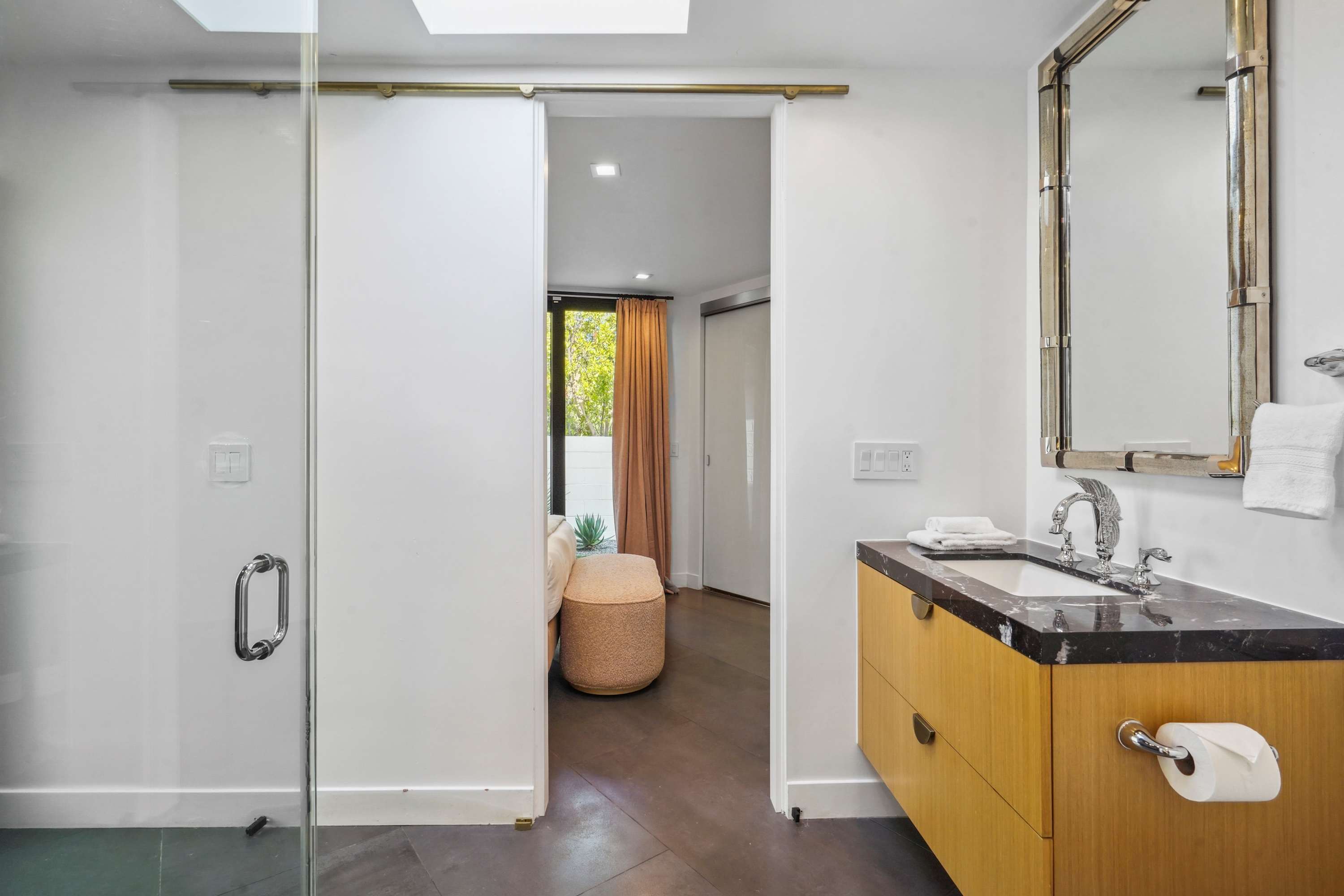 Sleek glass doors and custom wood cabinetry lead to the bedroom, creating a seamless transition between spaces.