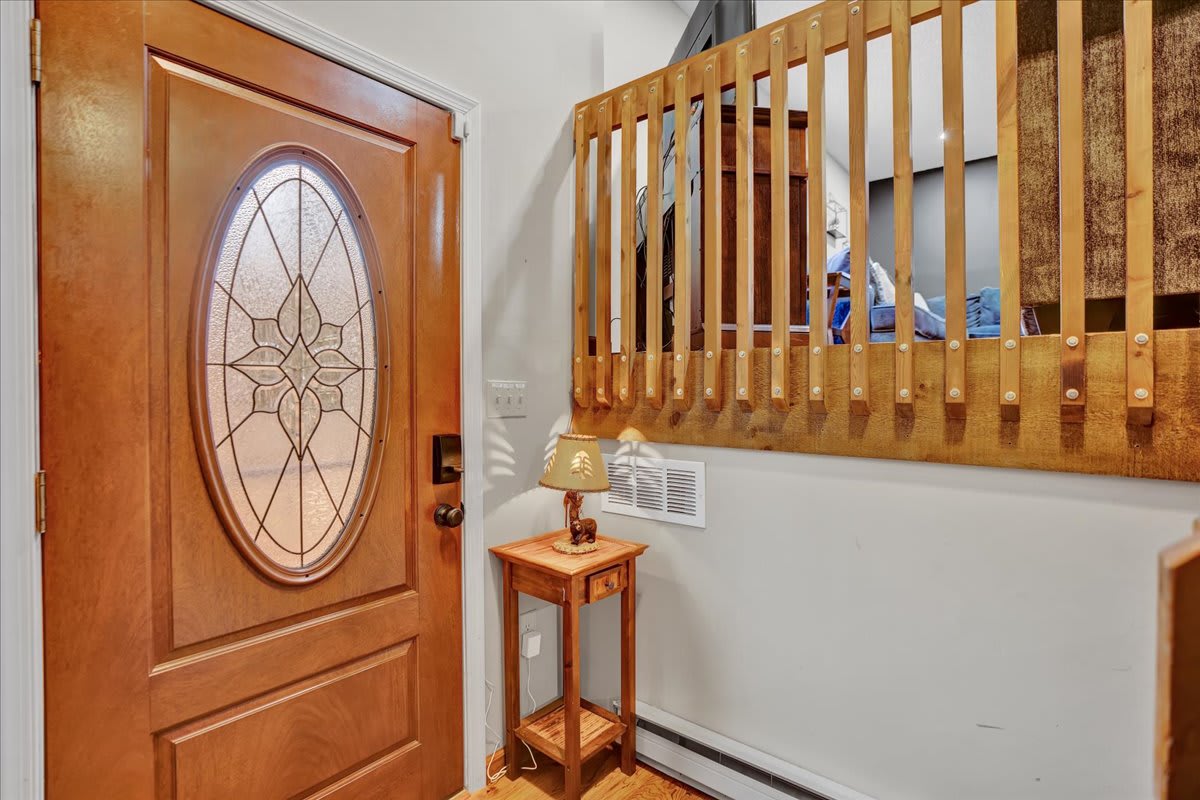 Welcoming Entryway – A charming entrance with rustic wood railings, a decorative glass door, and soft lighting to create a warm first impression.