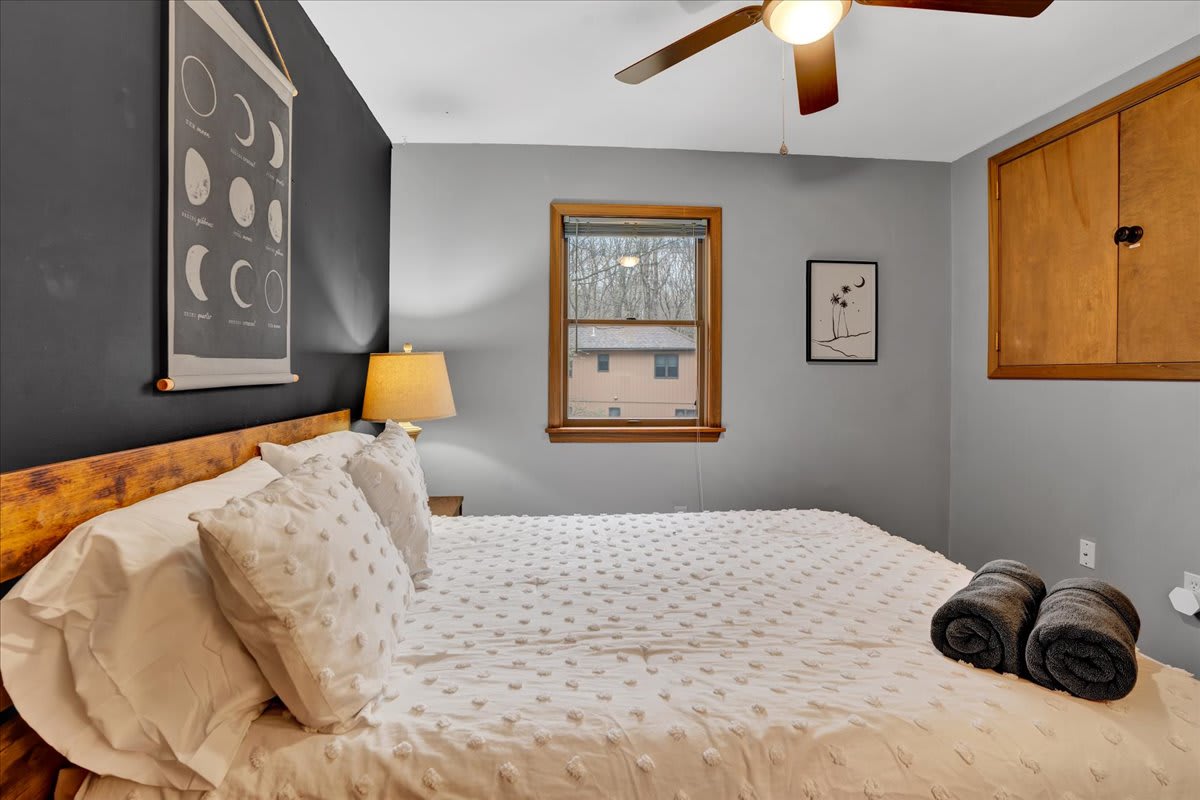 Warm & Inviting Bedroom Retreat – A cozy bedroom with soft lighting, wooden accents, and plush bedding for a peaceful night’s sleep.