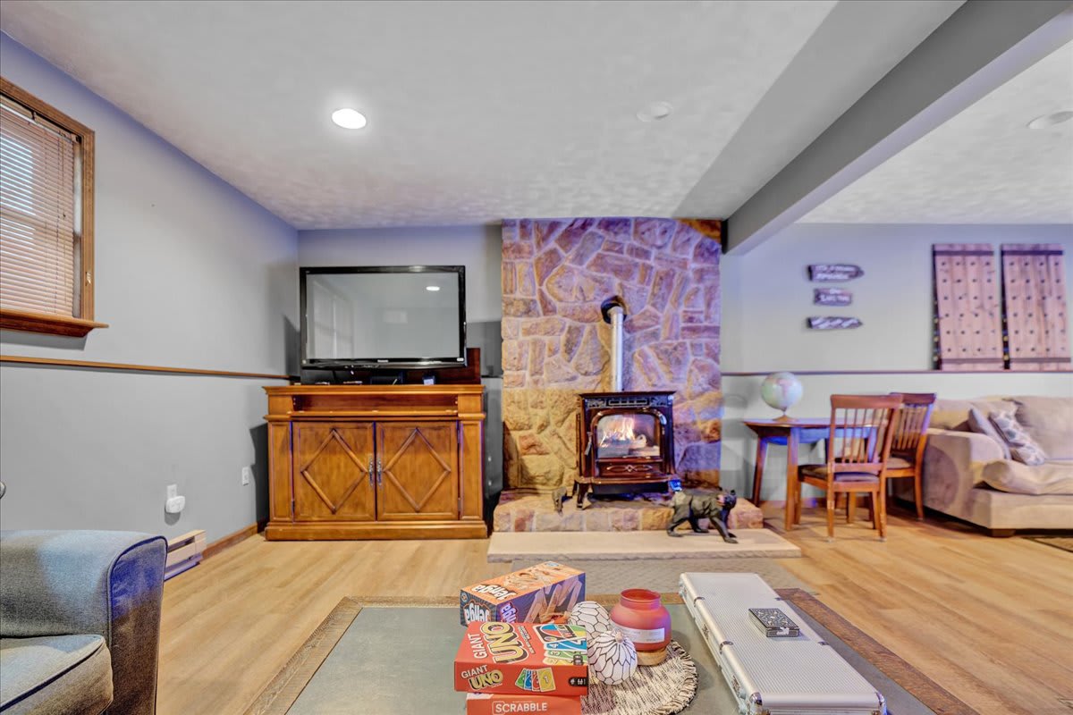 Cozy Living Room with a Rustic Touch – A warm and inviting space featuring a stone fireplace, wooden accents, and plush seating, perfect for relaxing after a long day.