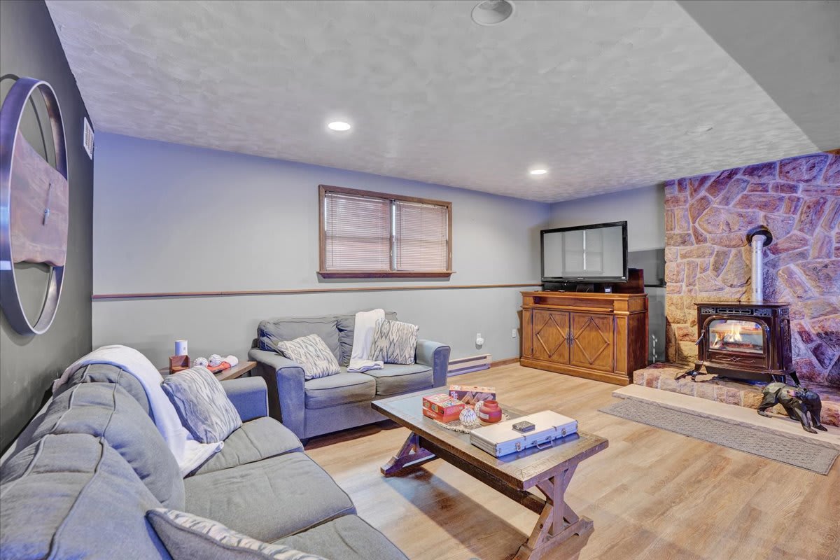 Rustic Meets Modern Living Area – A cozy lounge space with a charming fireplace, a sectional sofa, and a stylish blend of rustic and contemporary decor.