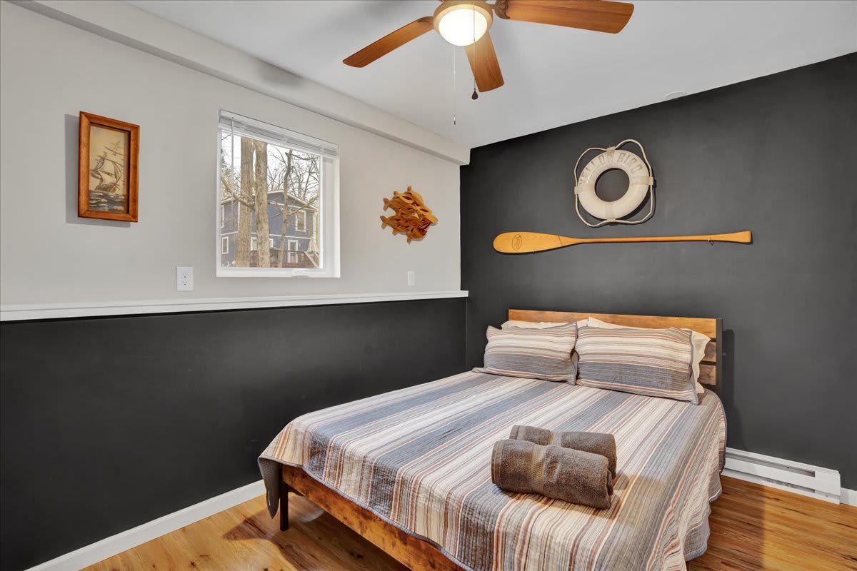 Rustic & Modern Bedroom Fusion – A cozy space with a sleek black-and-white palette, a wooden oar accent, and warm lighting for a relaxed atmosphere.