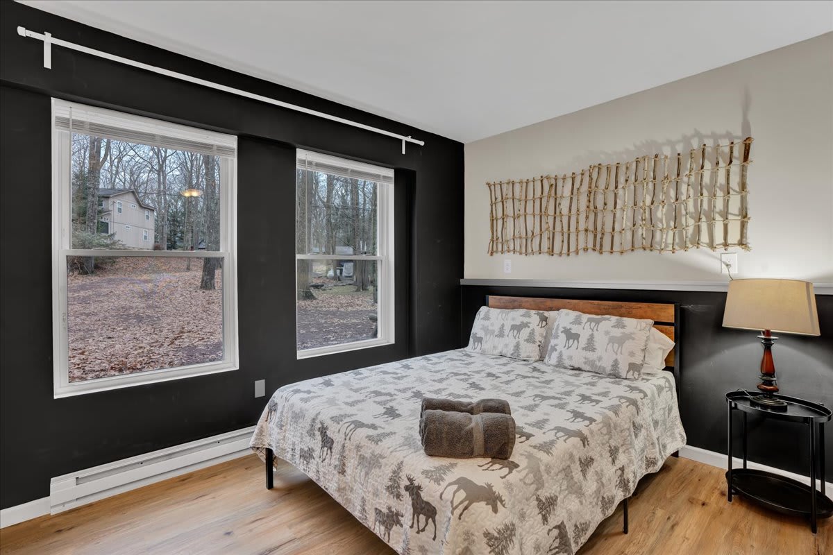 Bright & Spacious Twin Room – A stylish bedroom featuring 3 beds, large windows, and a sleek black accent wall, creating a cozy yet modern retreat.