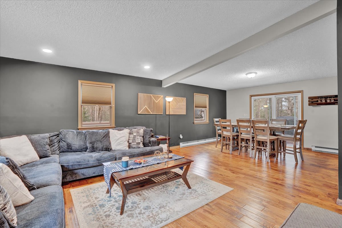 Open-Concept Lounge & Dining – A beautifully designed space with a large sectional sofa, a rustic dining area, and modern touches for a welcoming atmosphere.