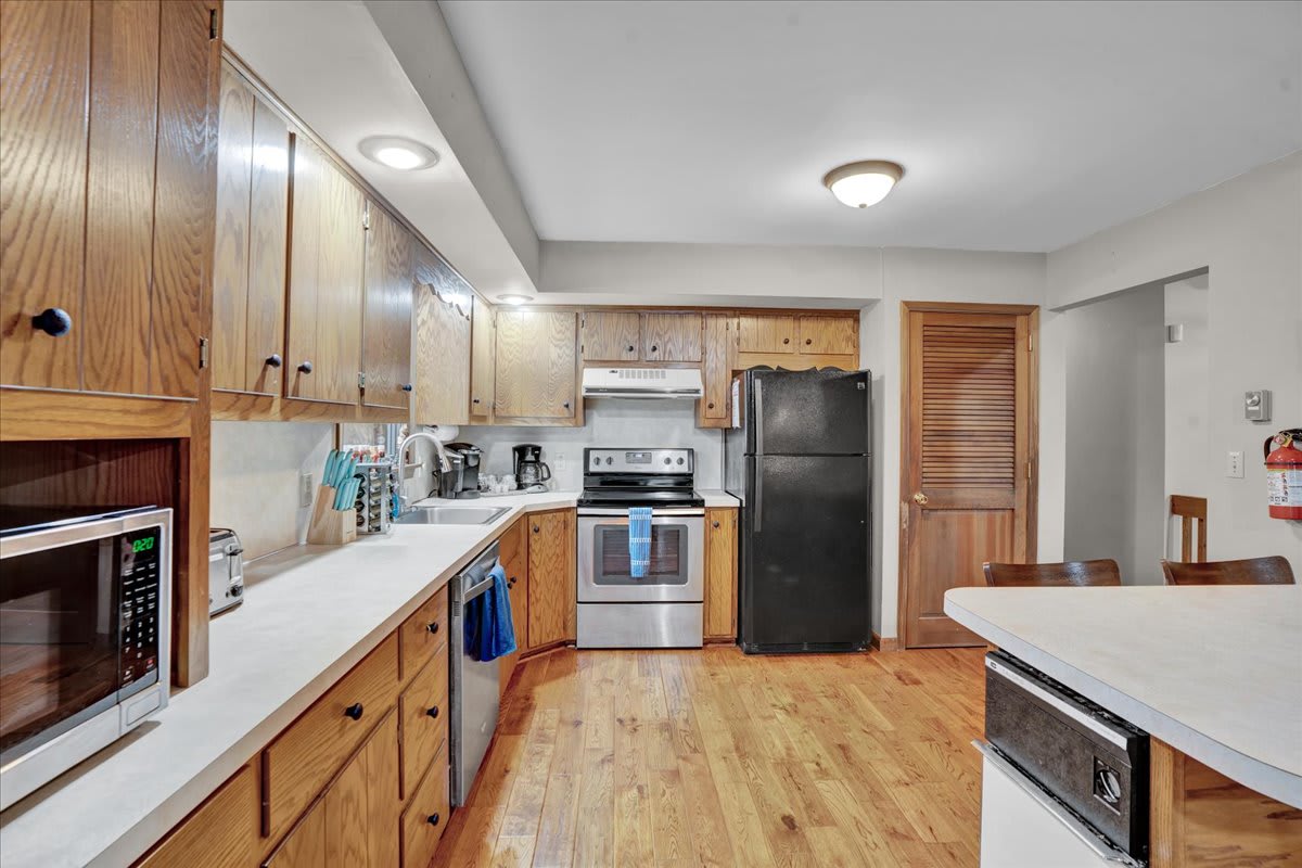 Spacious & Practical Kitchen Layout – A classic kitchen featuring warm wooden cabinetry, modern appliances, and a cozy yet functional atmosphere.