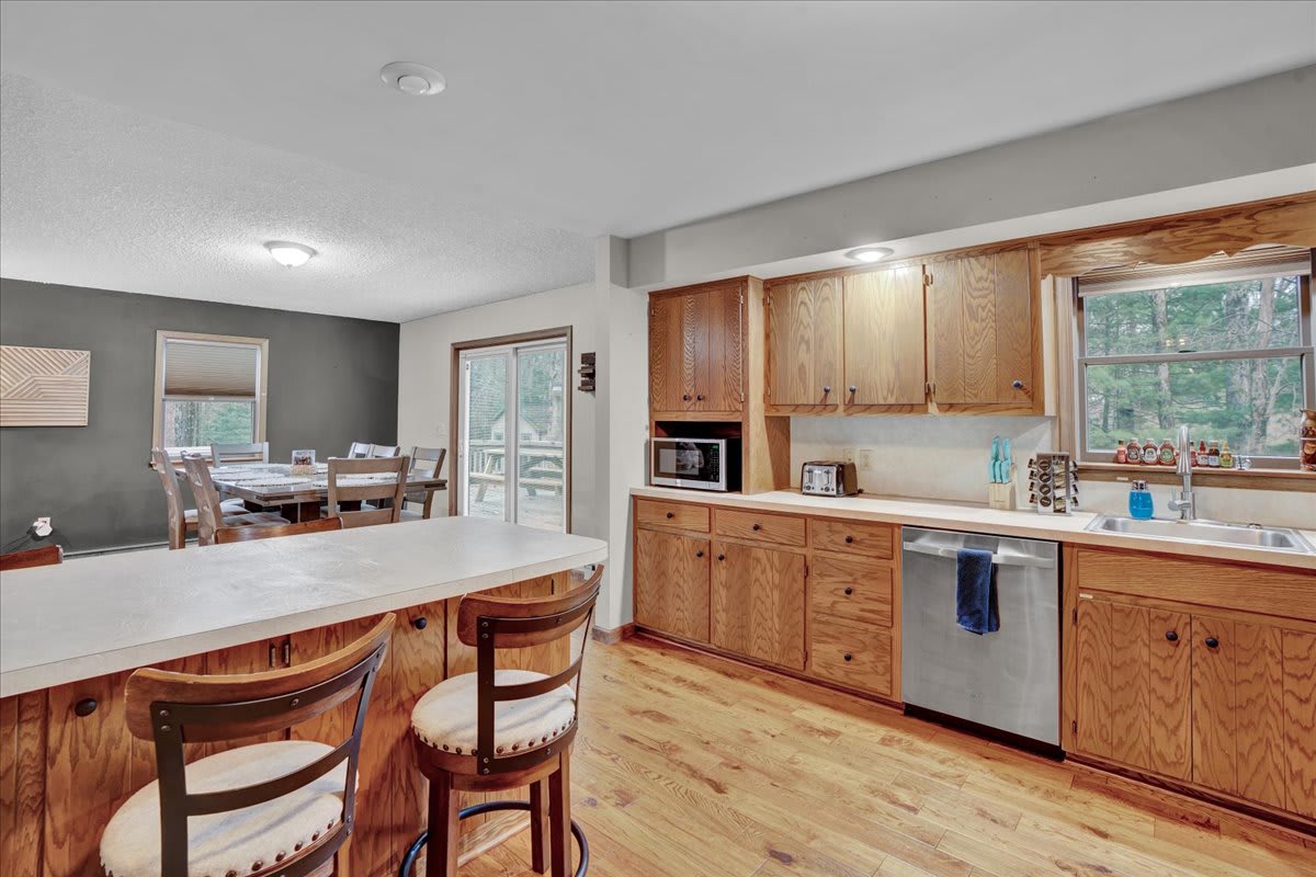 Warm & Spacious Kitchen – A welcoming kitchen with rich wooden cabinetry, a long breakfast bar, and an open flow to the dining area for easy entertaining.