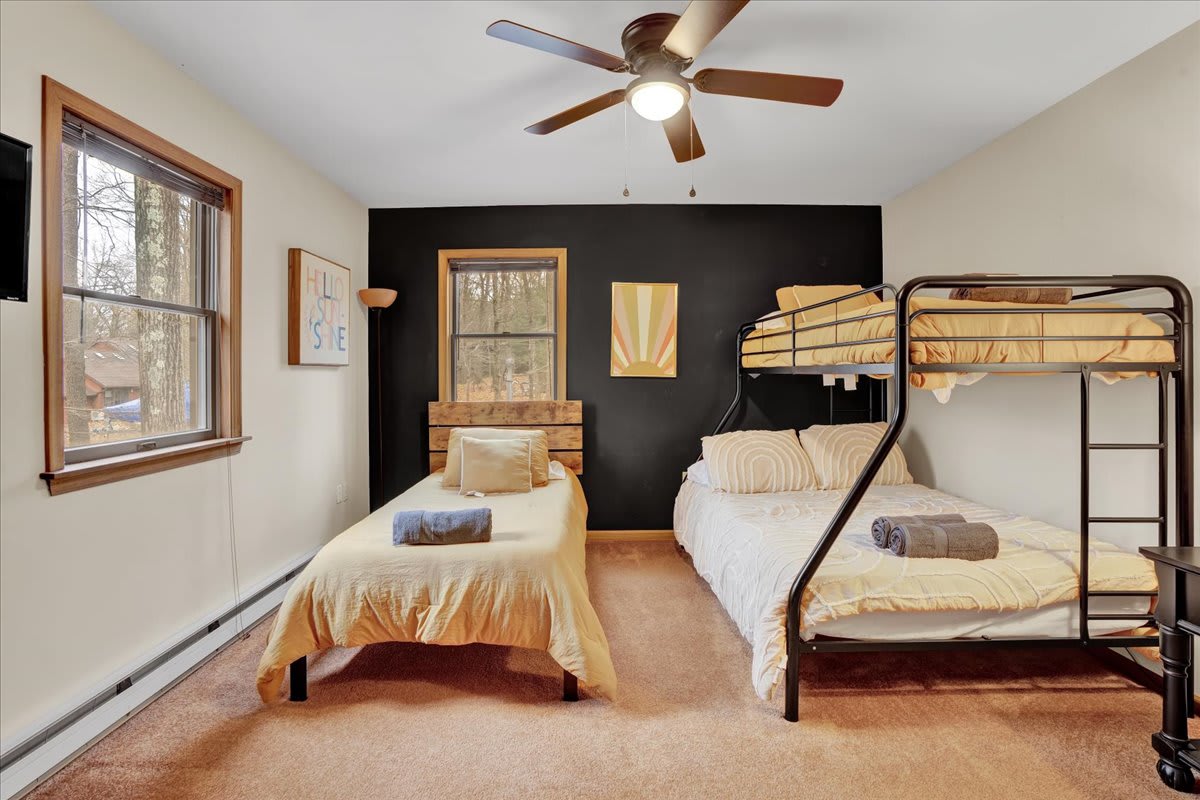 Comfortable & Spacious Bunk Room – A cozy bedroom featuring a bunk bed and single bed setup, ideal for families or groups looking for a restful stay.