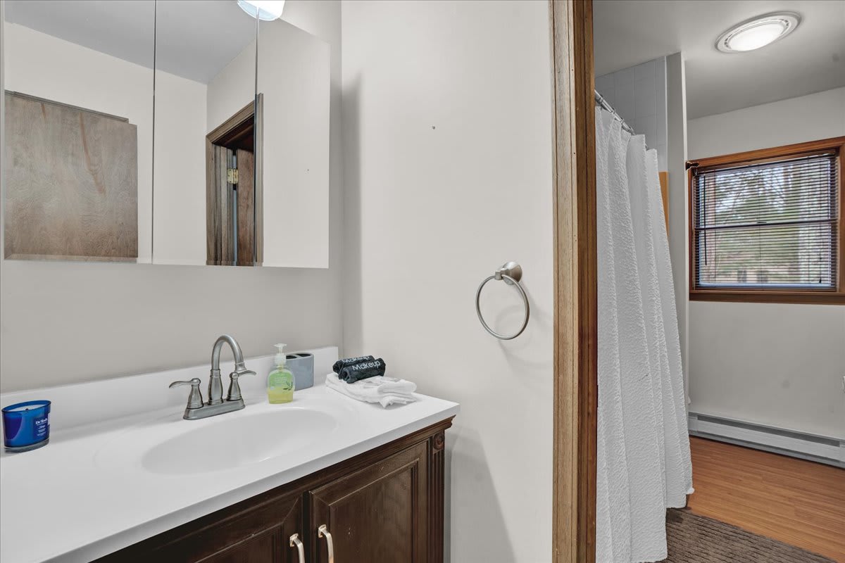 Bright & Simple Bathroom – A clean and practical bathroom with a sleek vanity, large mirror, and soft lighting for a refreshing experience.