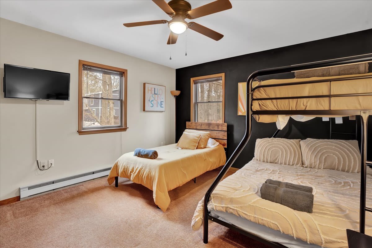 Cozy & Functional Bunk Room – A stylish and practical bedroom featuring a mix of a bunk bed and a single bed, perfect for families or groups.