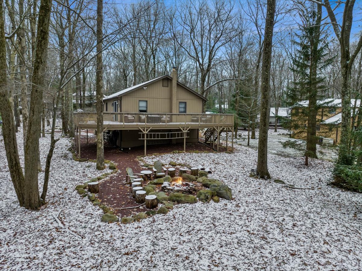 Serene Winter Retreat – A cozy home nestled among the trees, with a light dusting of snow creating a peaceful and picturesque setting.