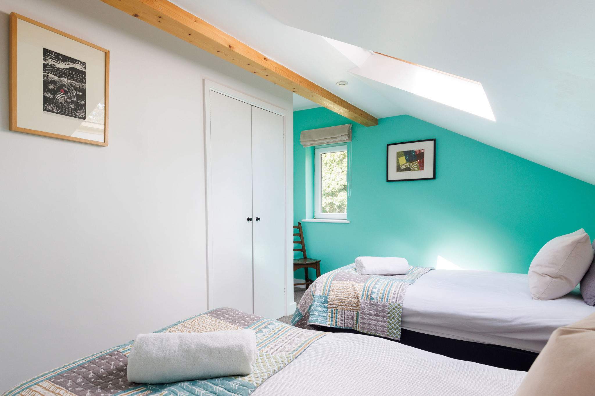 Light and bright twin room, with pops of colour and exposed beams.