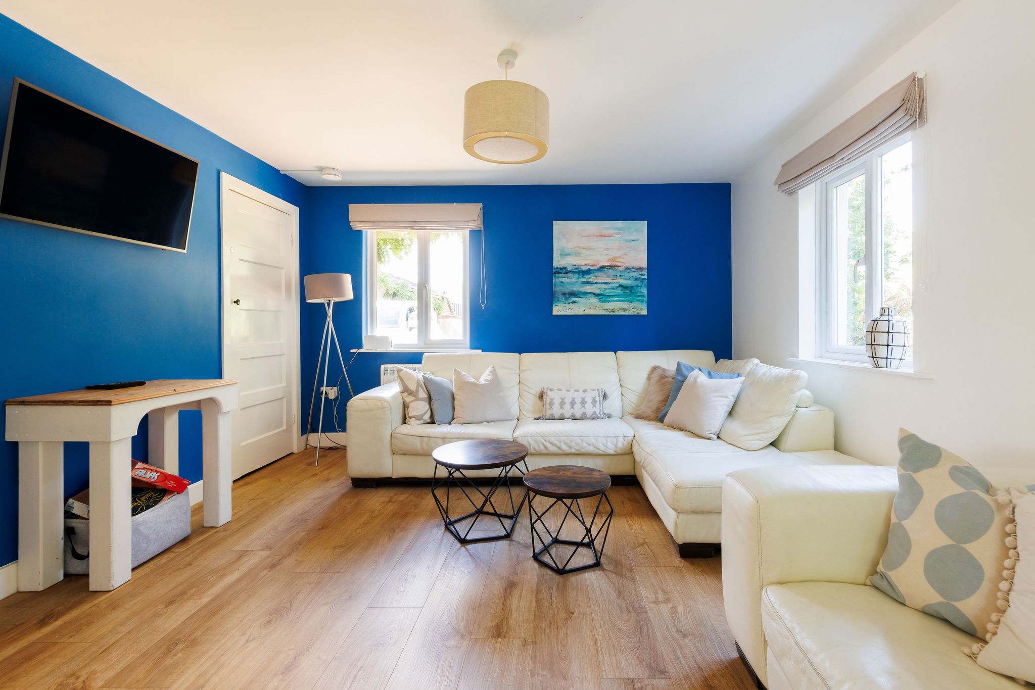 Relax in this spacious living area, featuring a comfy corner sofa, modern decor, and a large flat-screen TV, perfect for unwinding after a day of exploring the countryside.