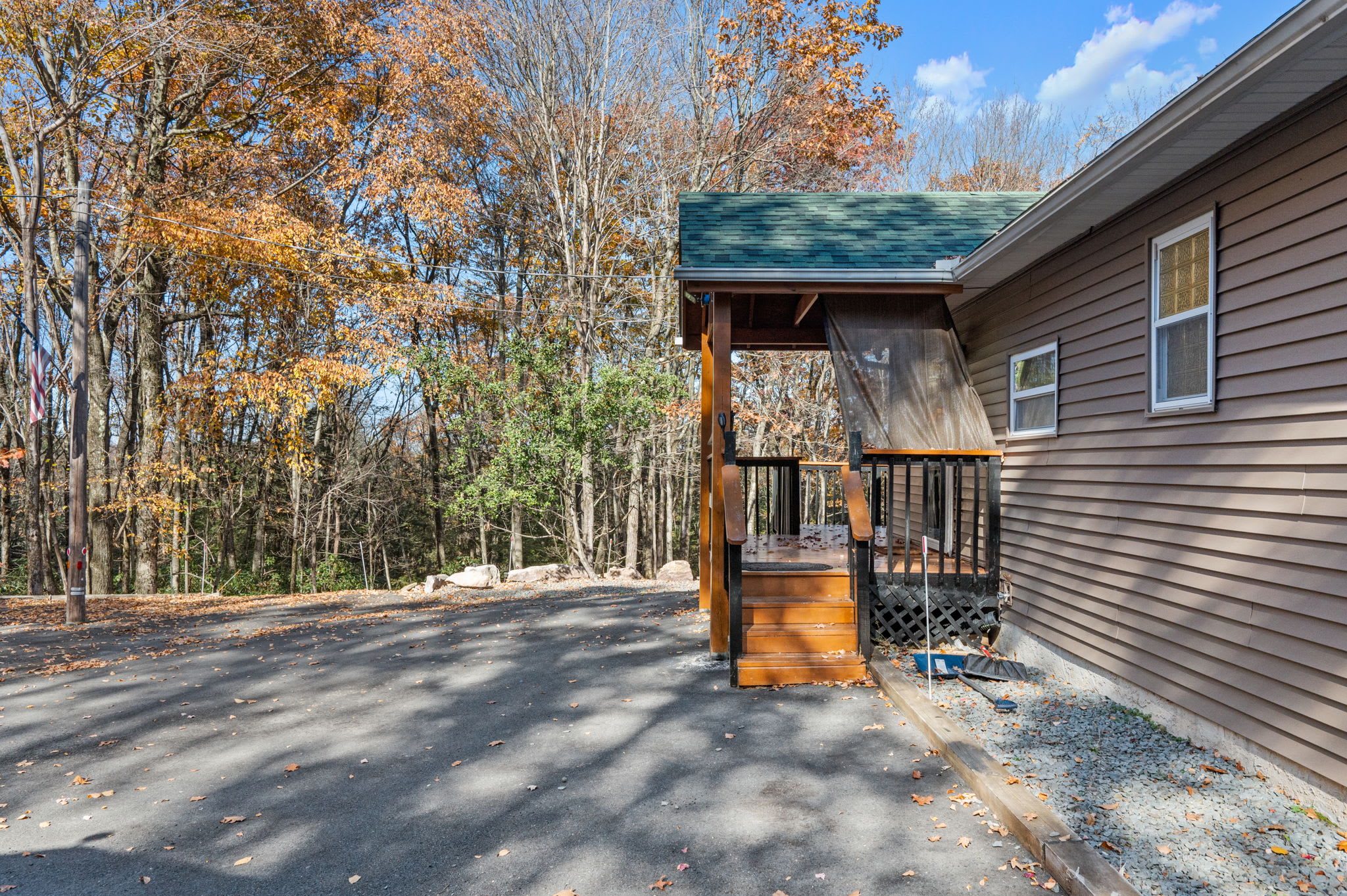 The generous driveway provides convenient access, while autumn foliage adds a touch of seasonal charm.