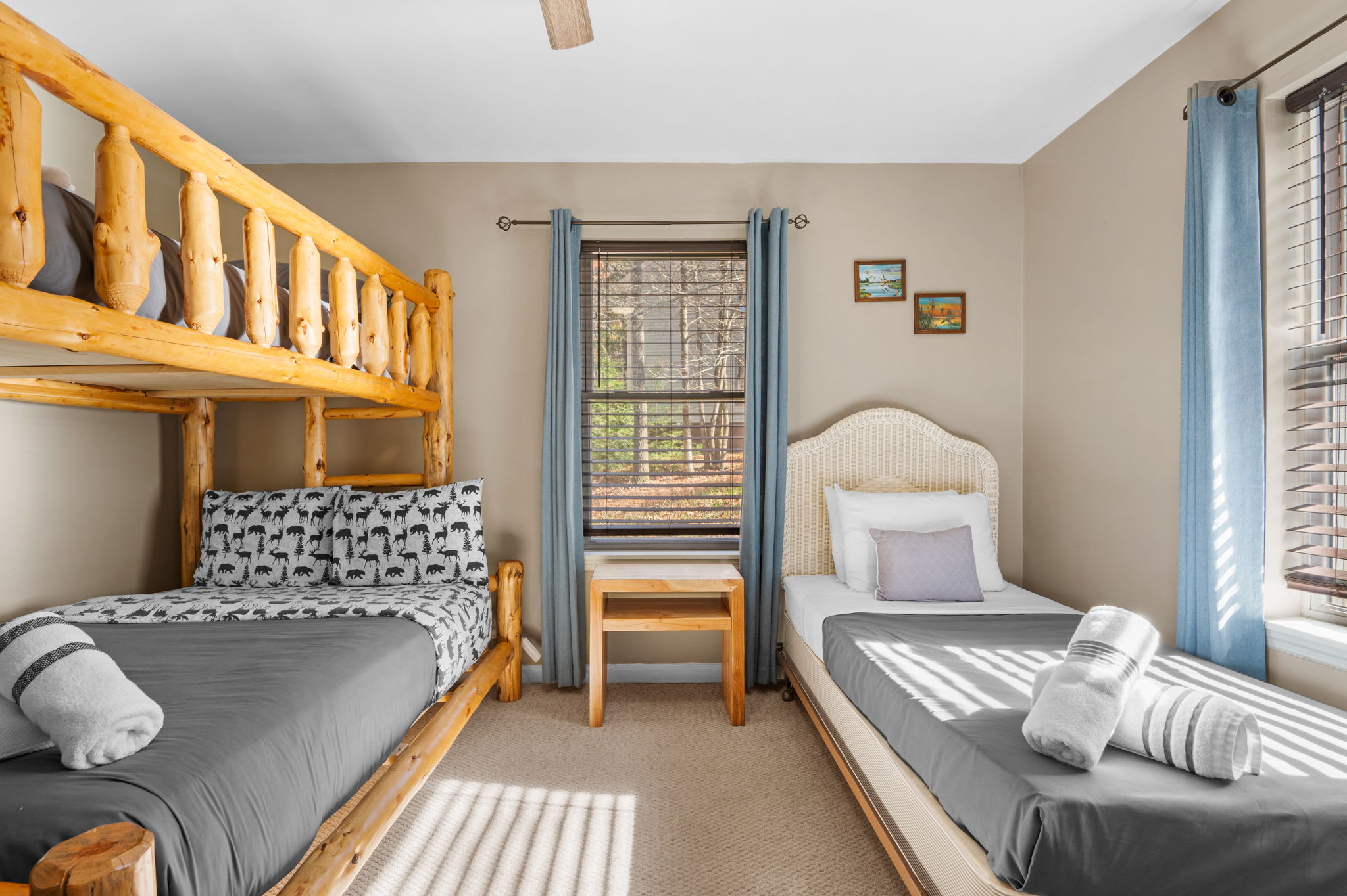 A rustic log bunk bed and wicker-framed twin create a cozy space for both kids and adults to unwind.