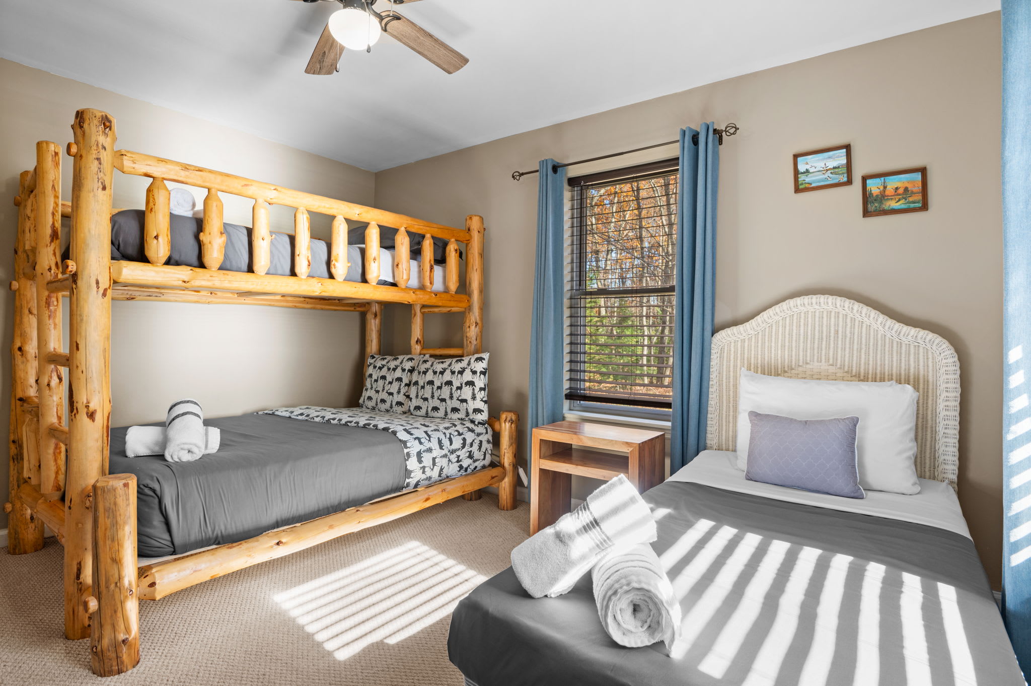 Large windows fill the room with natural light, highlighting the soft color palette and warm wood accents.