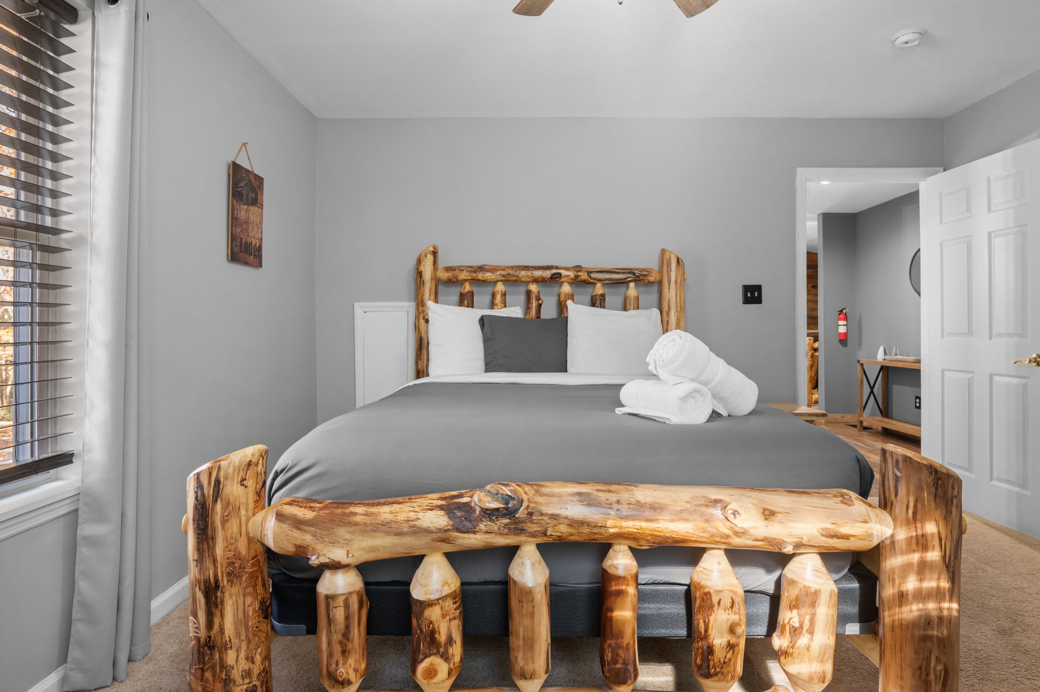 Crisp gray linens and soft carpeting create a tranquil atmosphere, perfect for a peaceful night’s rest.