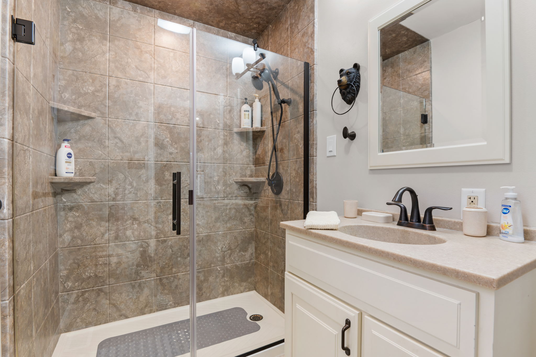 A spacious, glass-enclosed shower with warm tile creates a soothing, spa-like atmosphere.