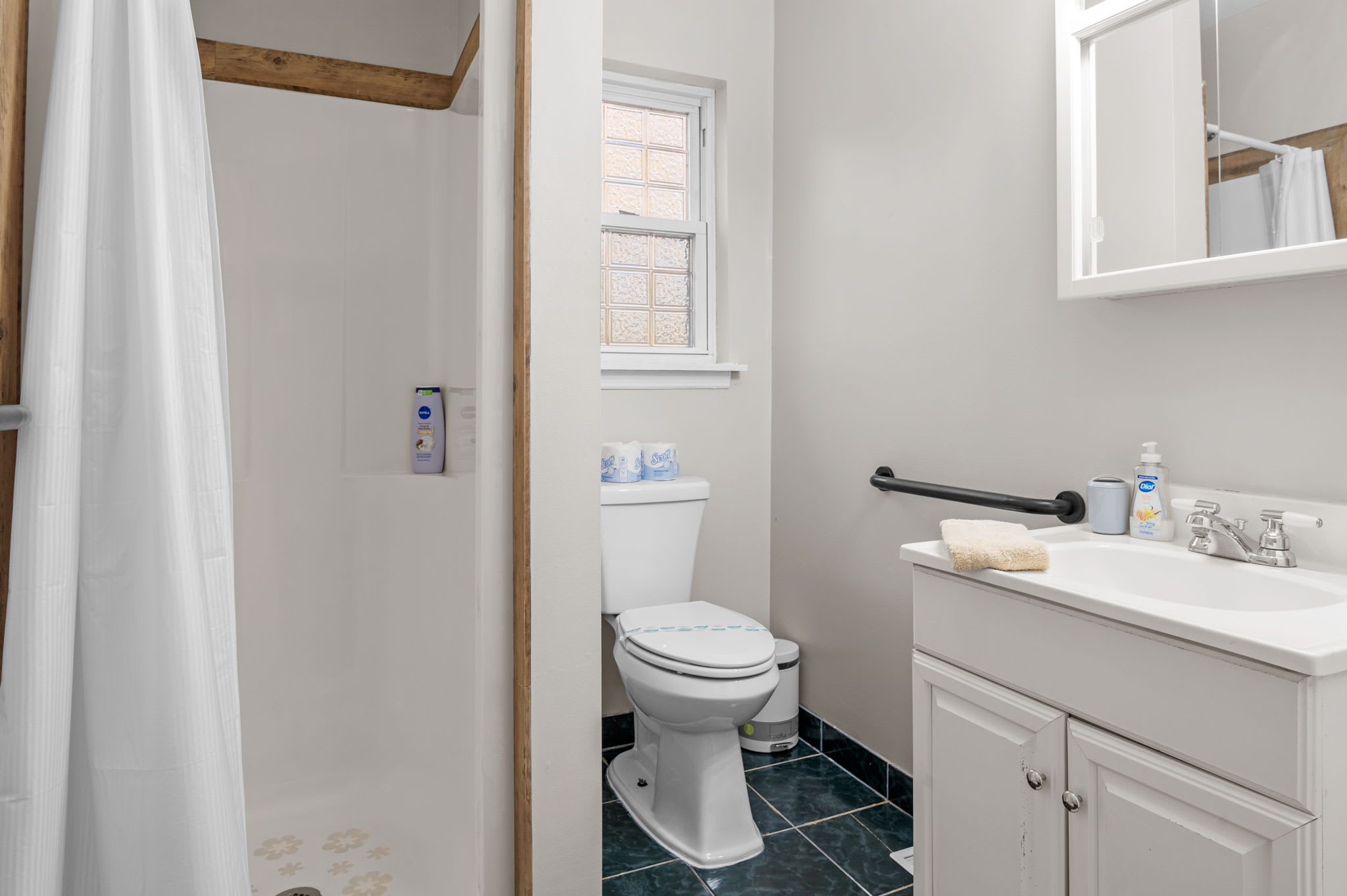 This bright, functional bathroom features a walk-in shower and a crisp, modern vanity.