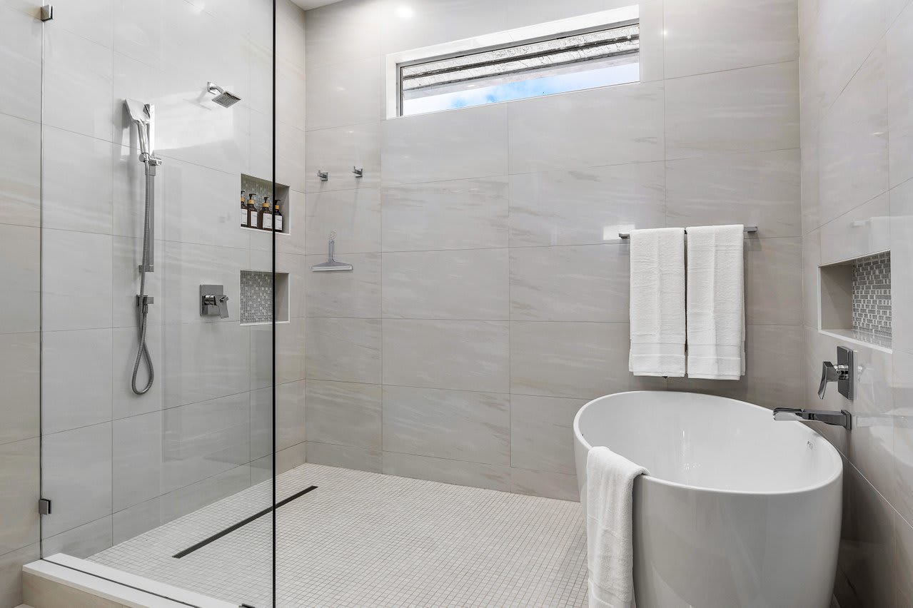 Unwind in the master bath with a freestanding soaking tub, spacious steam shower, and polished stone finishes.