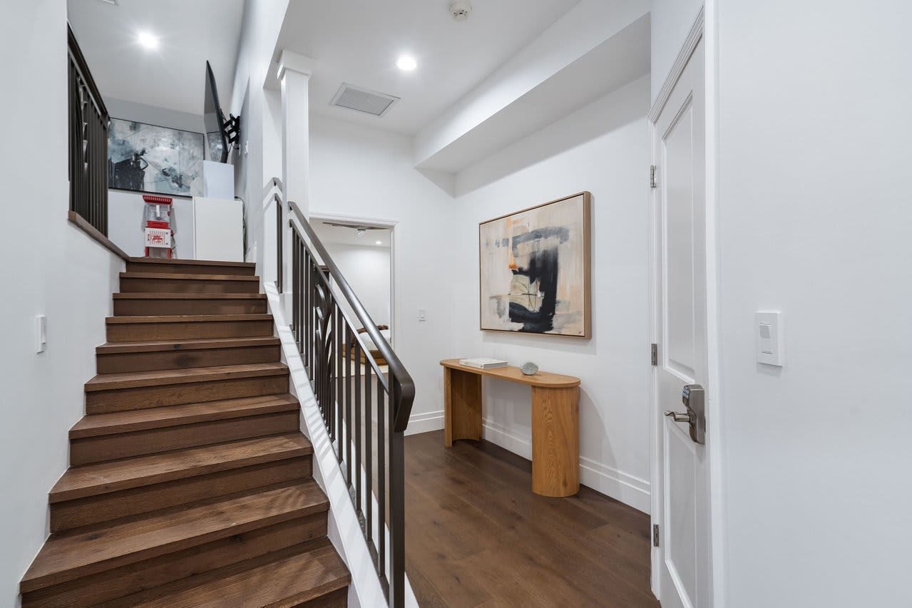 Step into refined elegance, where rich wood floors, modern artwork, and clean lines welcome you with understated sophistication.