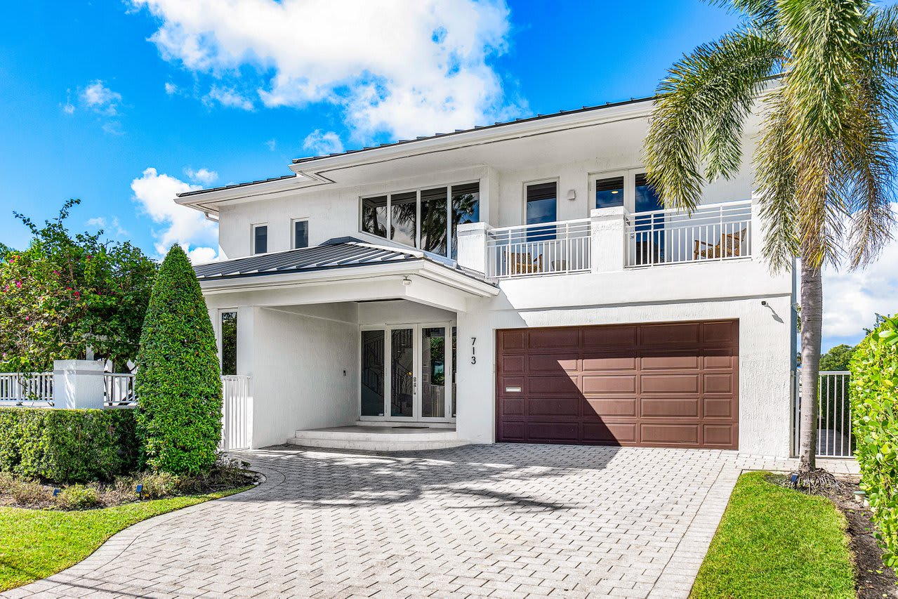 Step into elegance with a grand entryway framed by lush greenery and sophisticated architecture.
